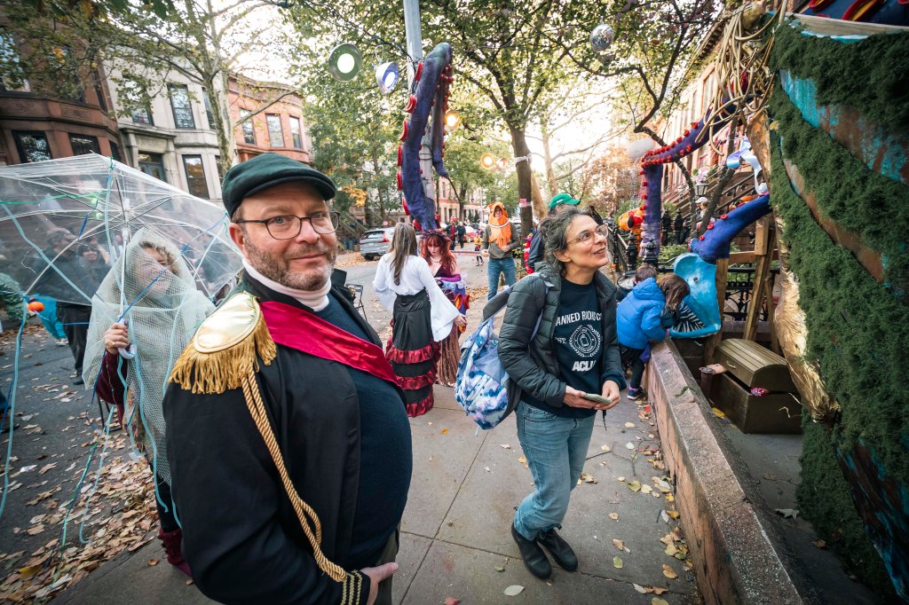People in Halloween costumes admiring decorations at the Iarussi family home in Park Slope.