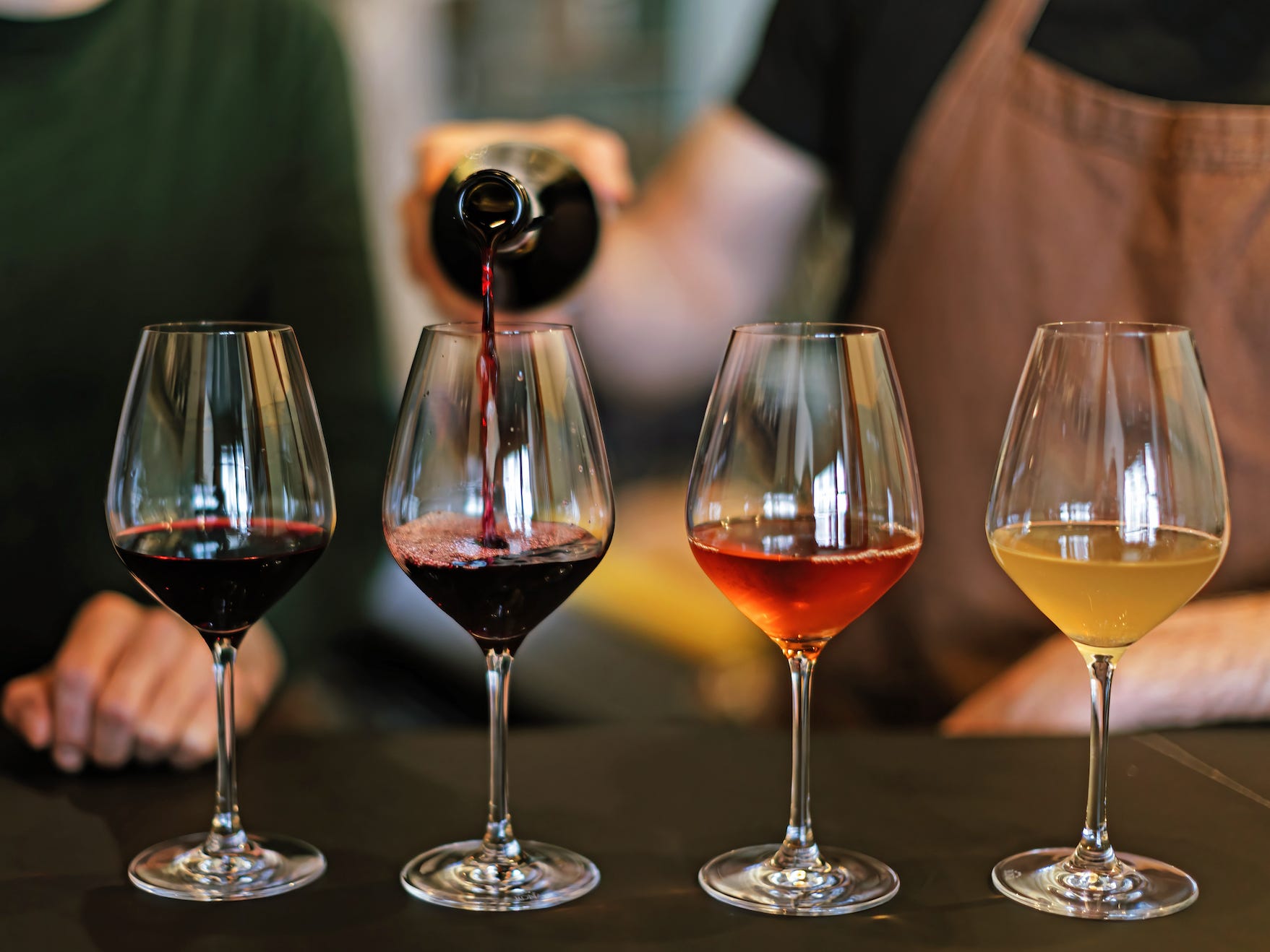 server pouring a flight of different wines