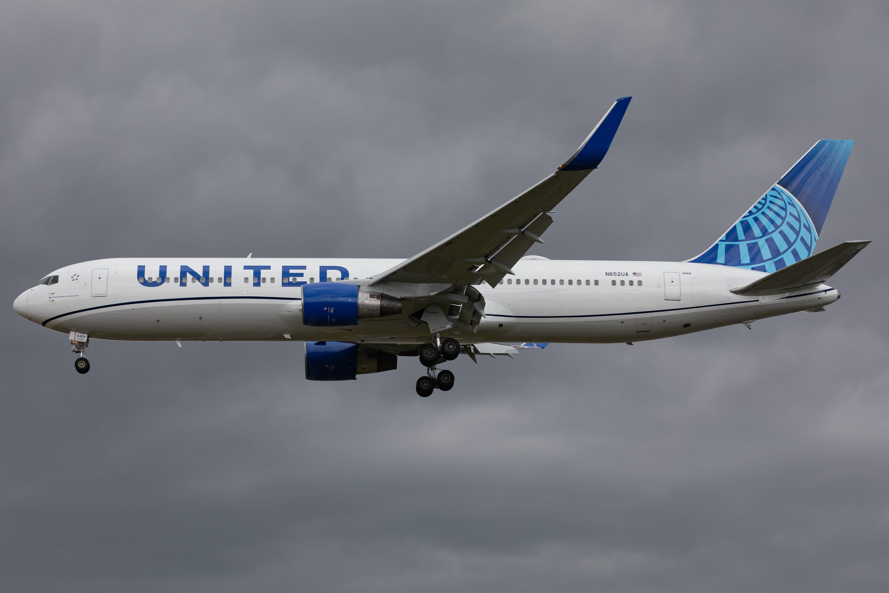 A United Airlines Boeing 767 flies near London Heathrow Airport in London, United Kingdom, against a gray sky on June 10, 2023.