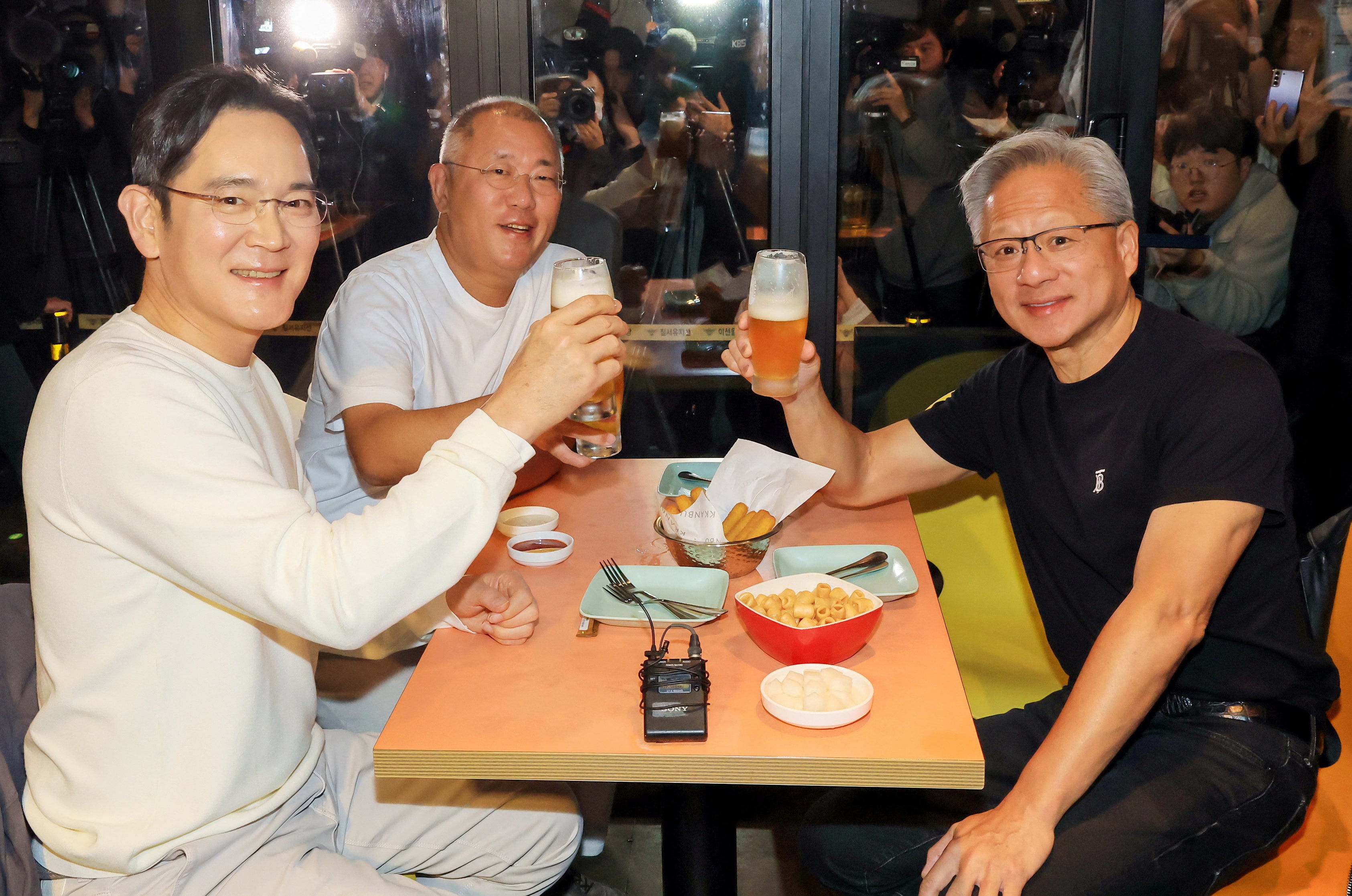 Nvidia CEO Jensen Huang, Samsung Electronics Chairman Jay Y. Lee and Hyundai Motor Group Executive Chair Euisun Chung make a toast at a fried chicken restaurant in Seoul, South Korea, October 30, 2025