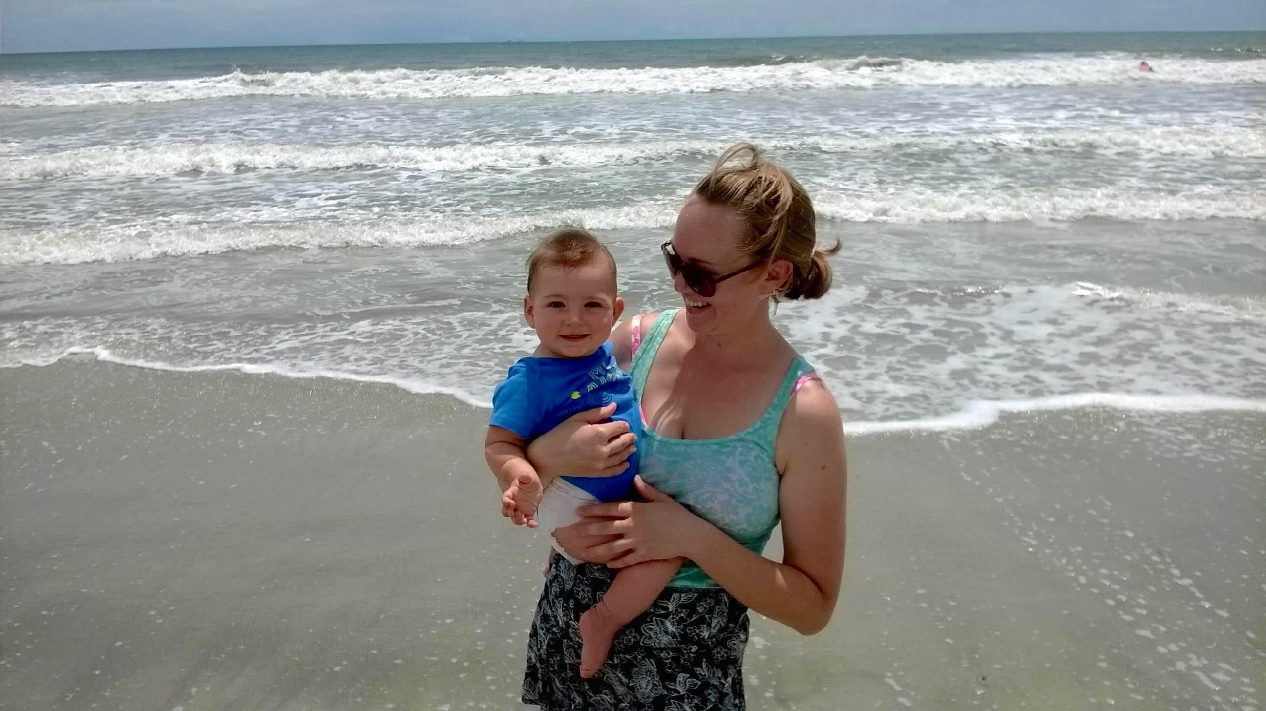 The author, shown on a beach with her son at 6-months old.