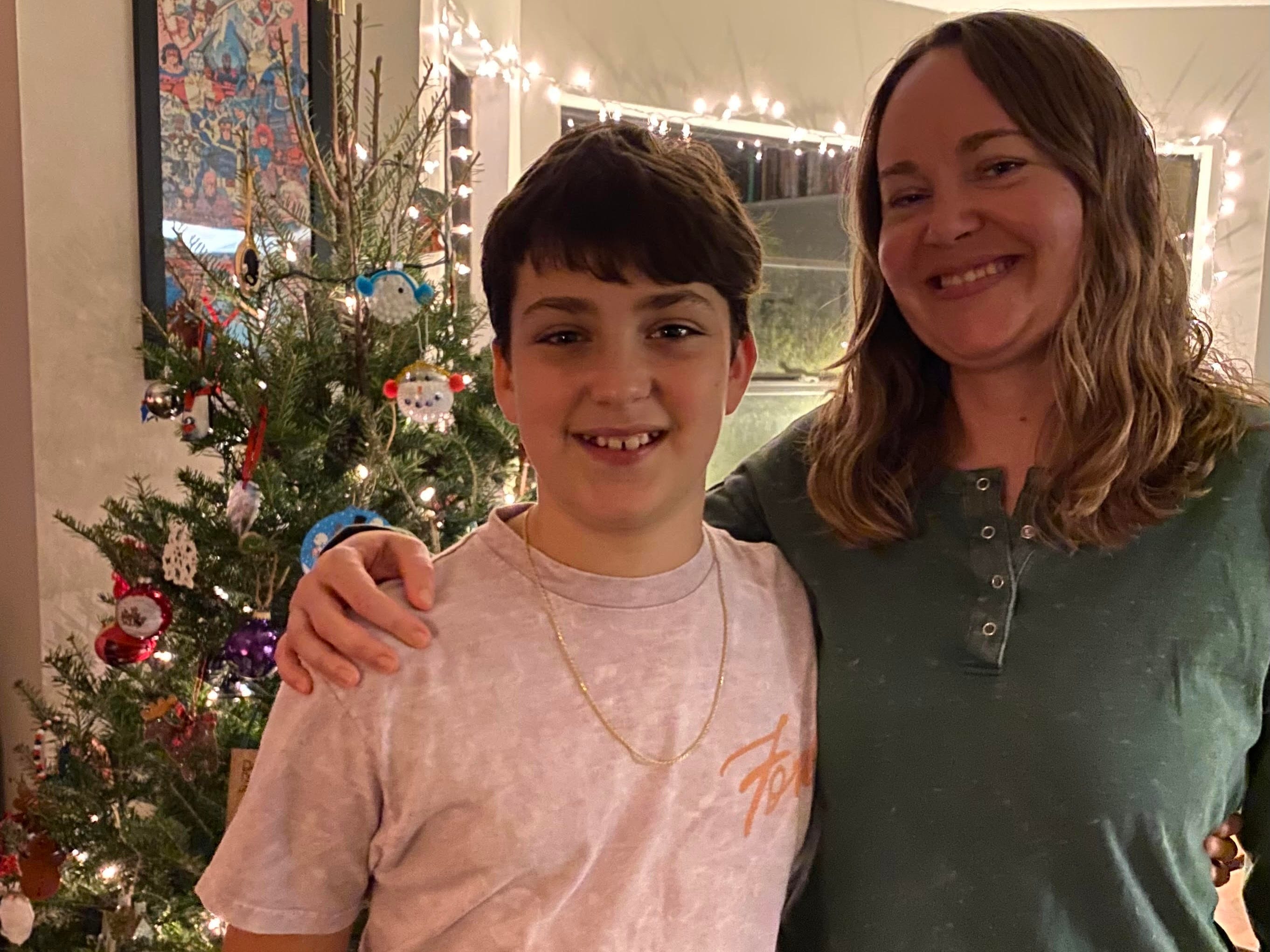 Ashley Archambault and her son standing in front of a christmas tree