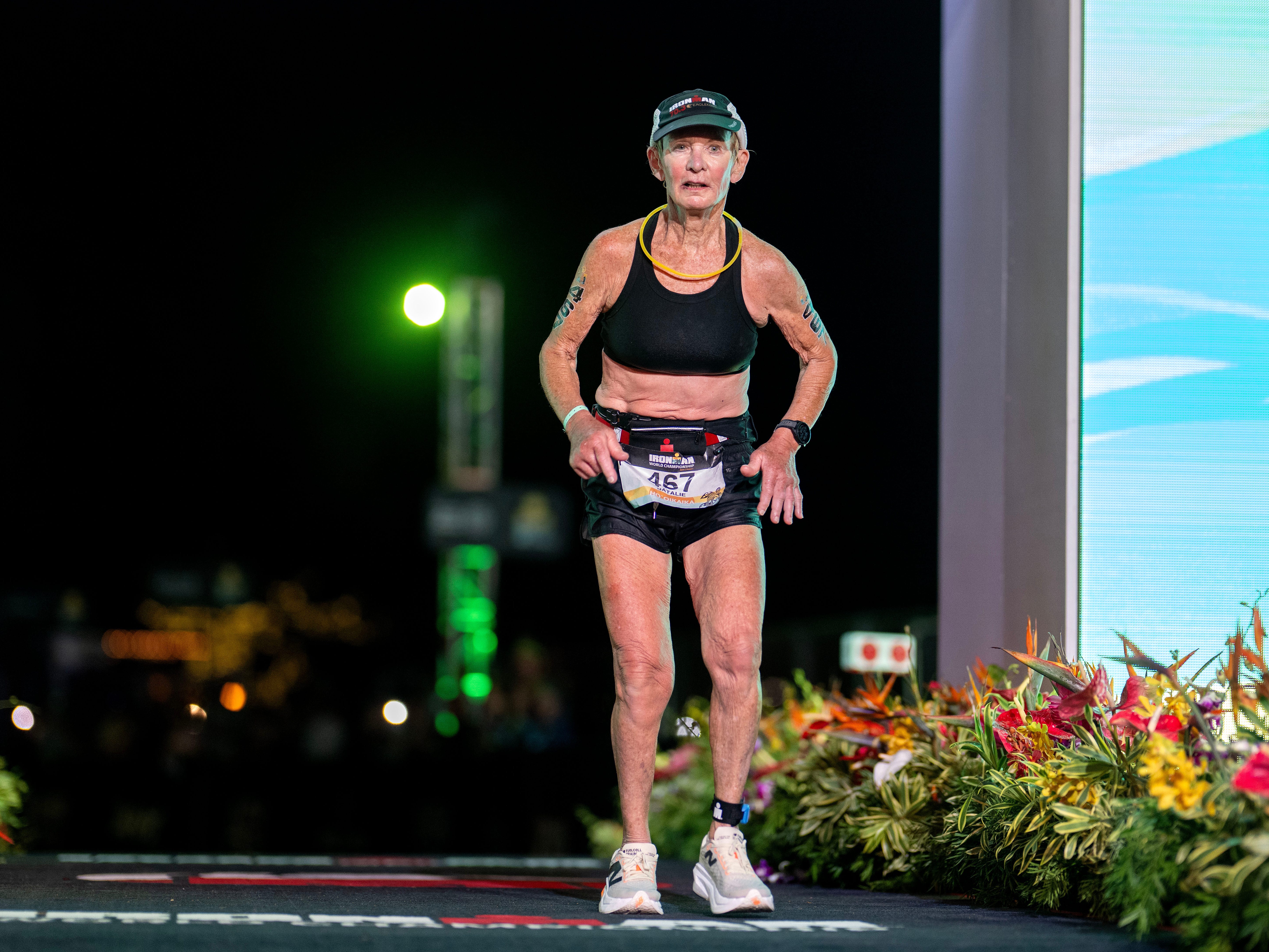 A senior woman at the finish line of an Ironman race.