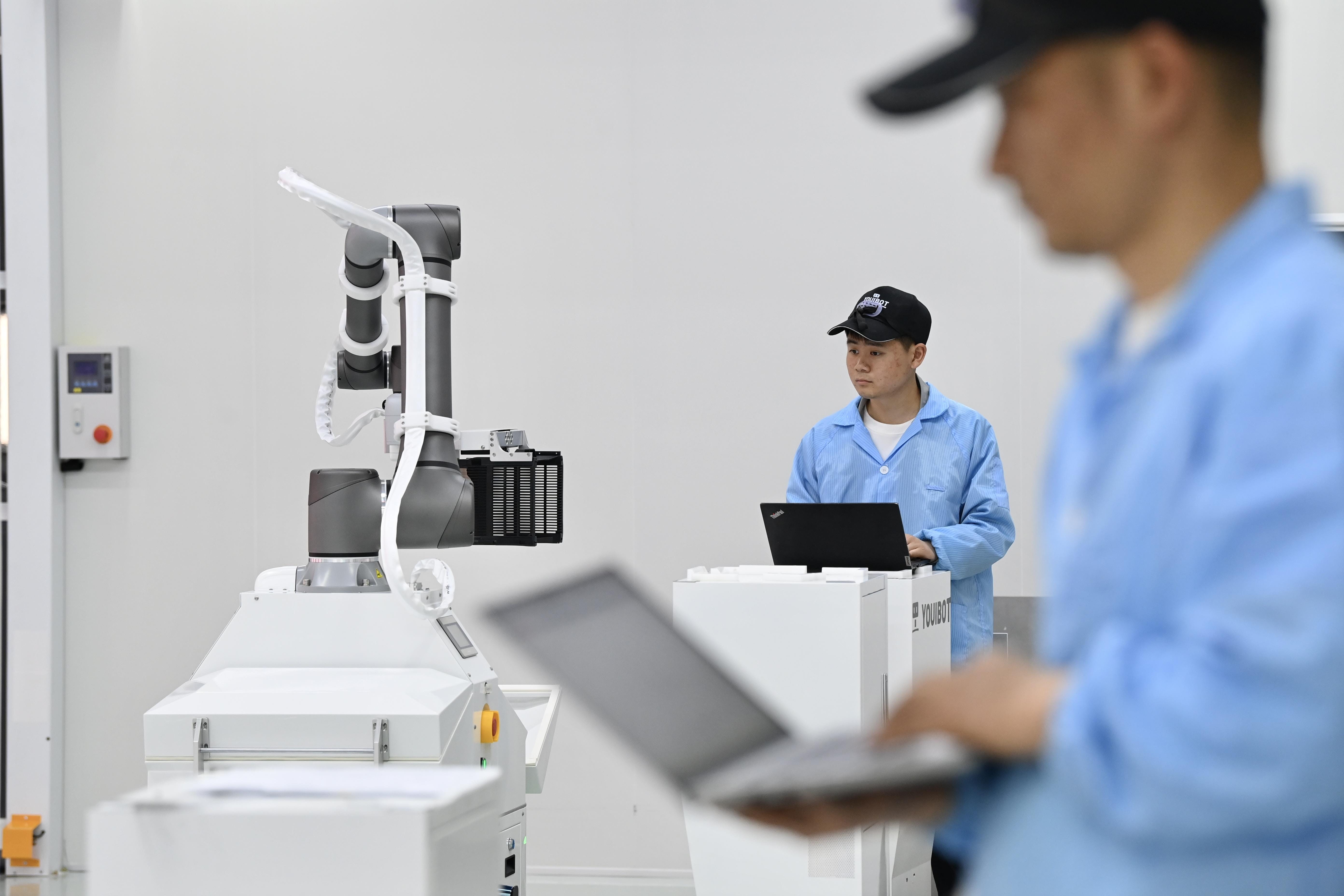 Technicians work at an industrial robot manufacturing factory in Hefei City, central China's Anhui Province, on April 8, 2025
