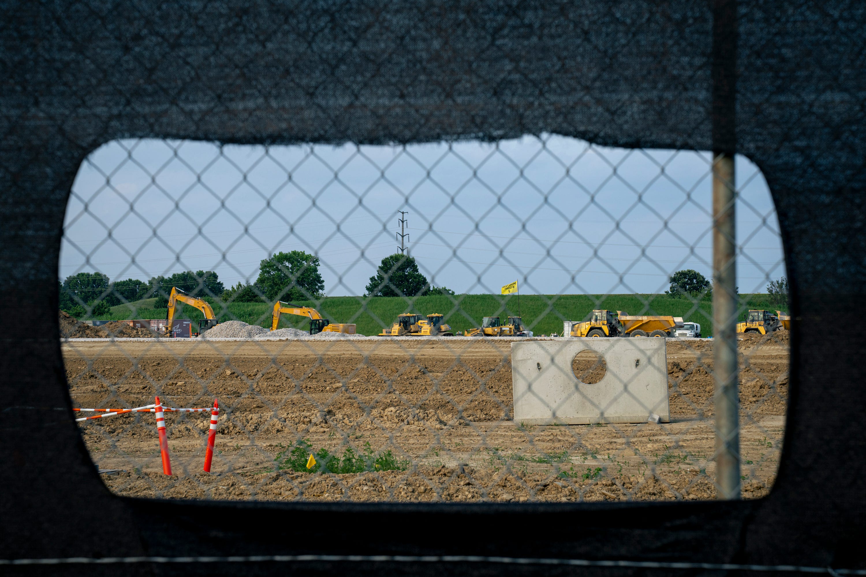 Construction equipment for a data center as seen through a chain-link fence