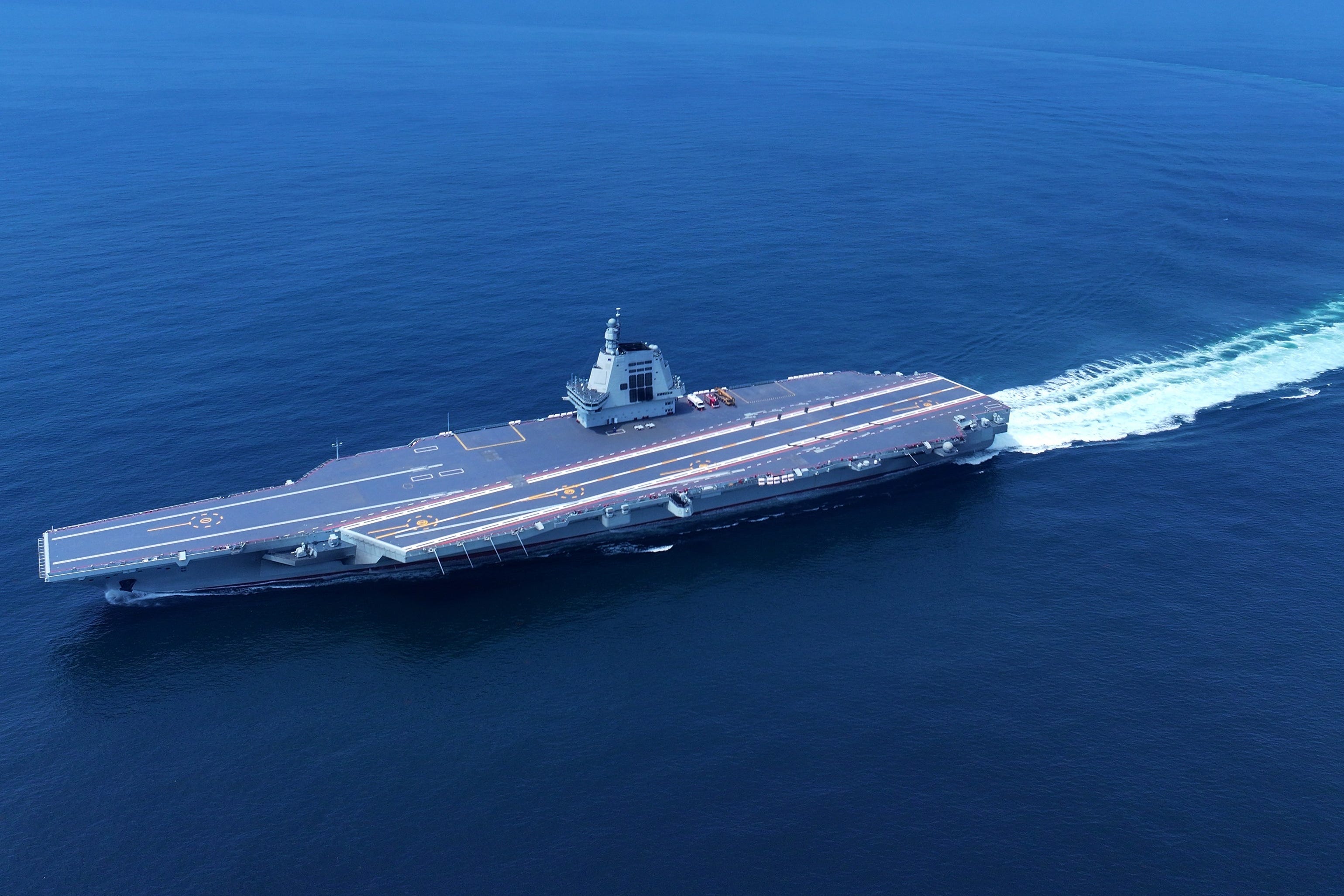 China's aircraft carrier CNS Fujian sailing in a deep blue ocean.