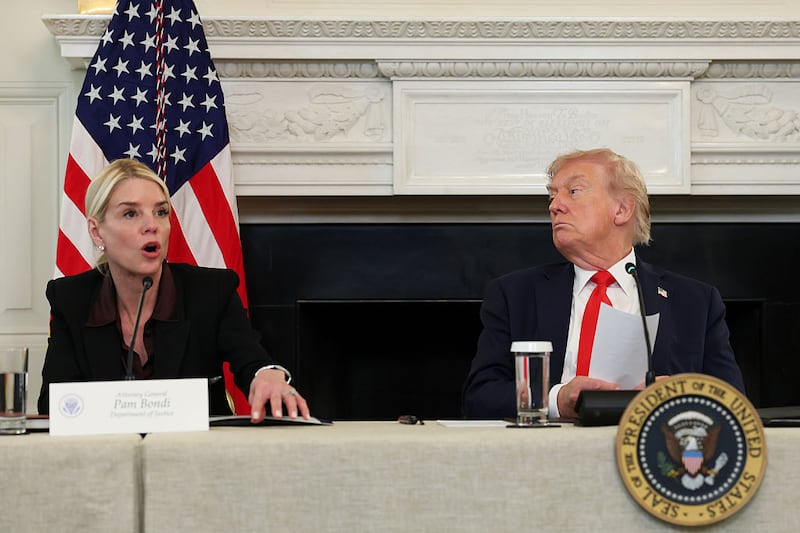 U.S. President Donald Trump reads a note handed to him by U.S. Secretary of State Marco Rubio he said was regarding Middle East peace talks as U.S. Attorney General Pam Bondi (L) speaks during a roundtable discussion in the State Dining Room of the White House on October 08, 2025 in Washington, DC.