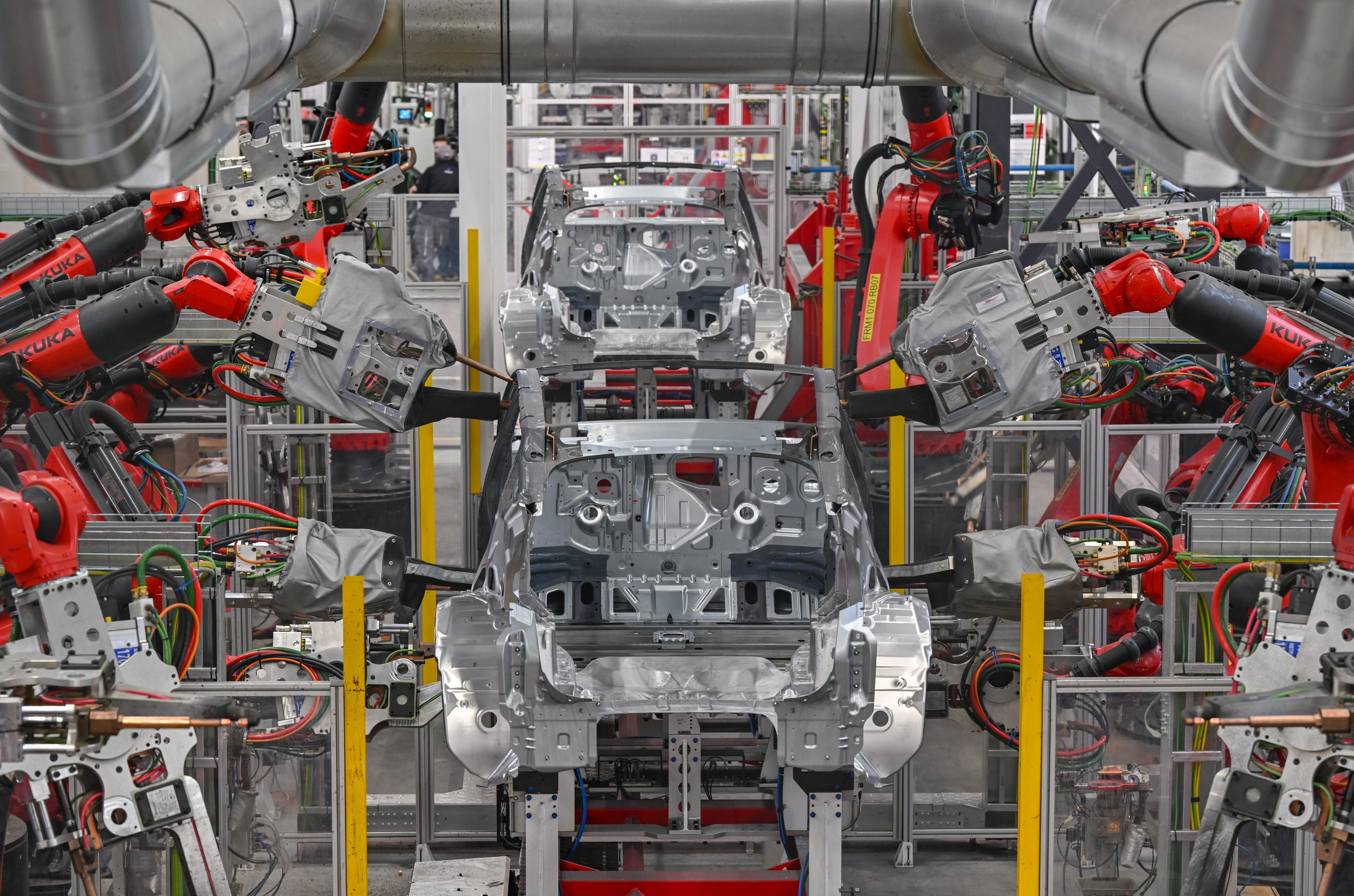Robots weld the body of a Model Y electric vehicle at a Tesla Gigafactory plant.
