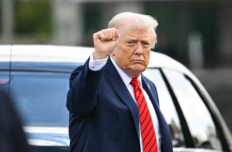 US President Donald Trump gestures as he exits his motorcade to walk to Marine One upon departure from Walter Reed National Military Medical Center after a medical checkup in Bethesda, Maryland, on October 10, 2025. (Photo by ANDREW CABALLERO-REYNOLDS / AFP)