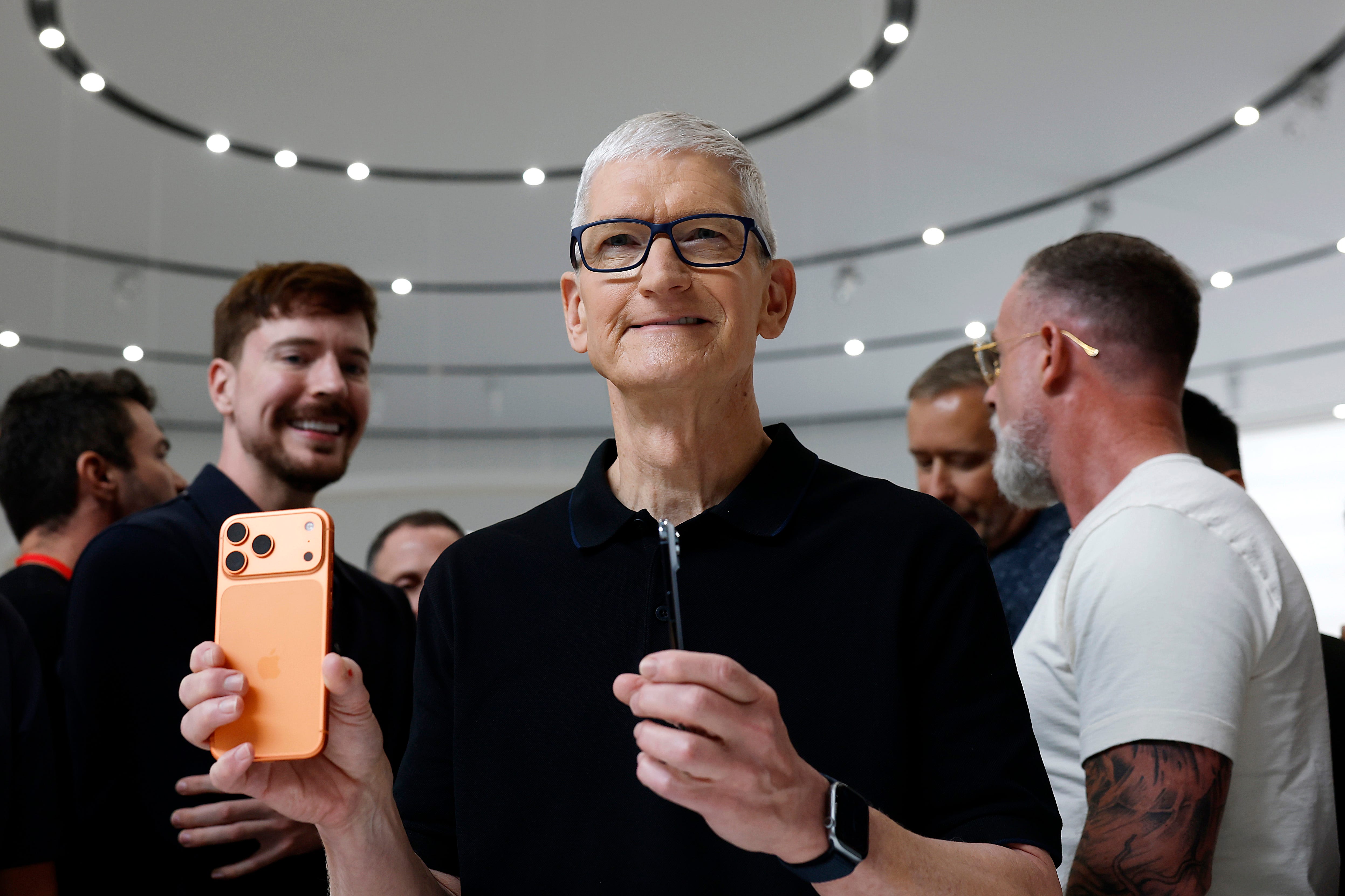 Apple CEO Tim Cook holding an iPhone