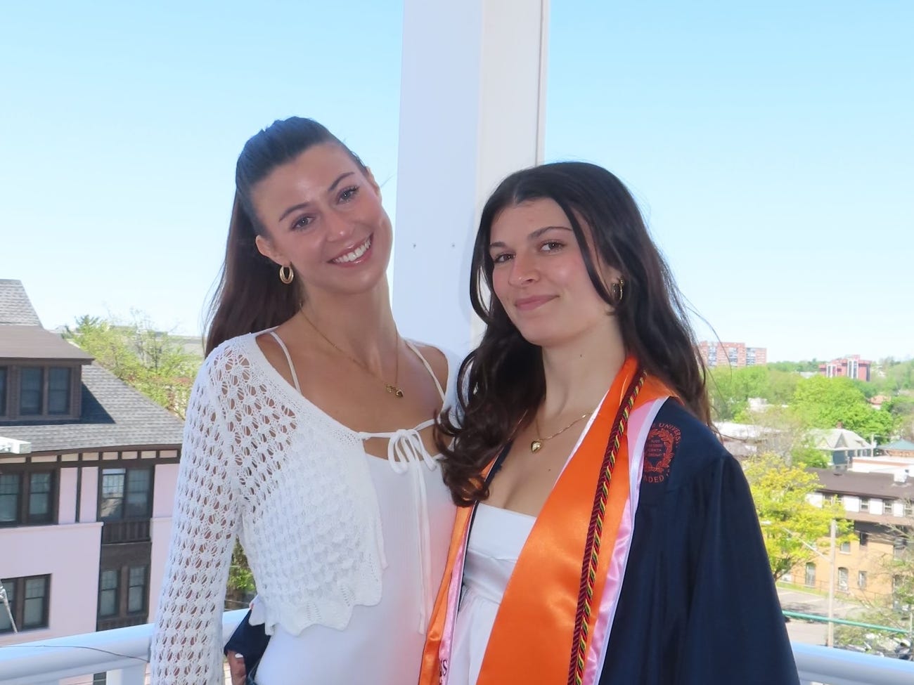 The author, right, and her sister posing. The author is wearing college graduation regalia.