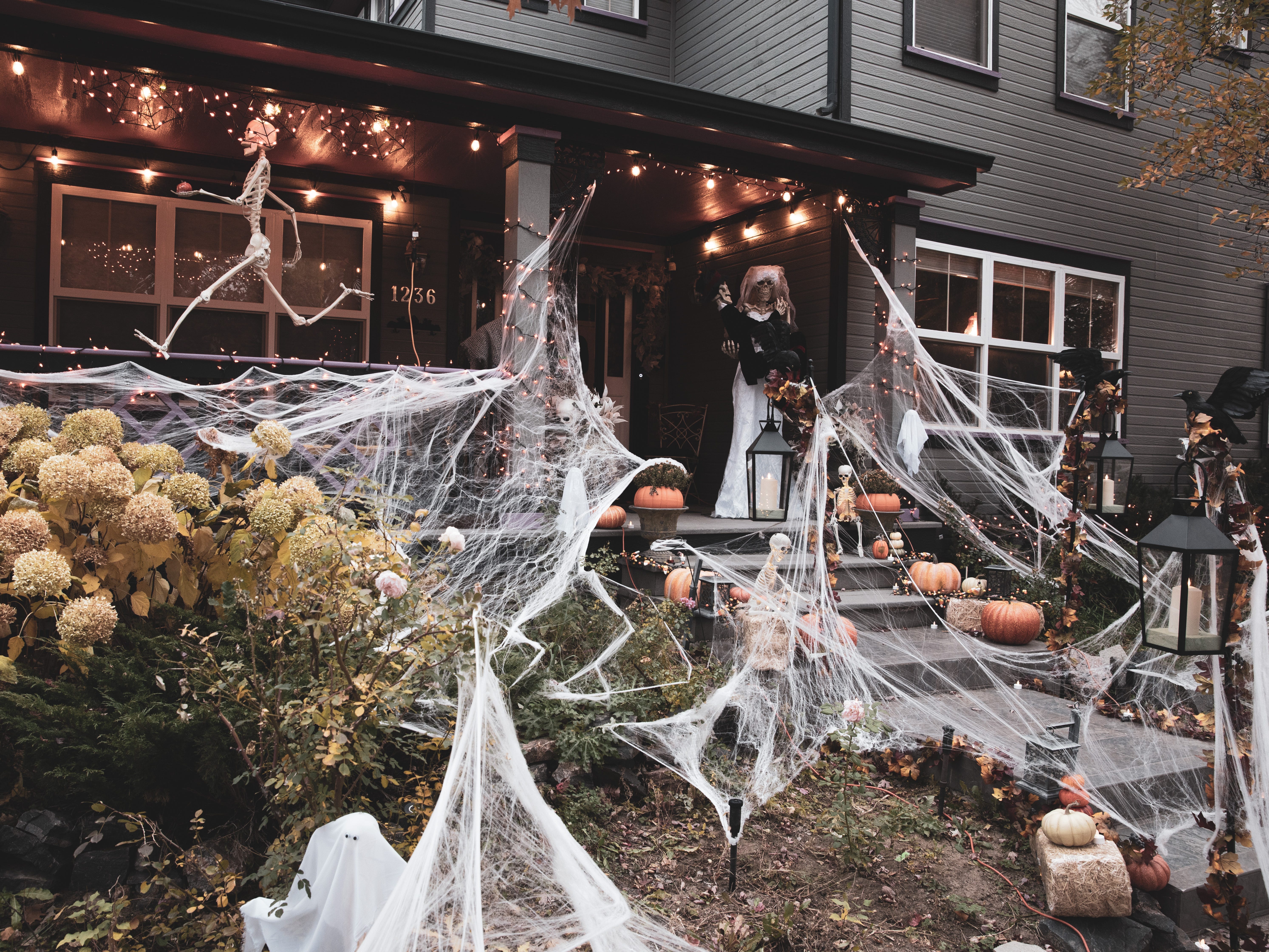 House exterior decorated with spiderwebs, skeletons and pumpkins ready for Halloween