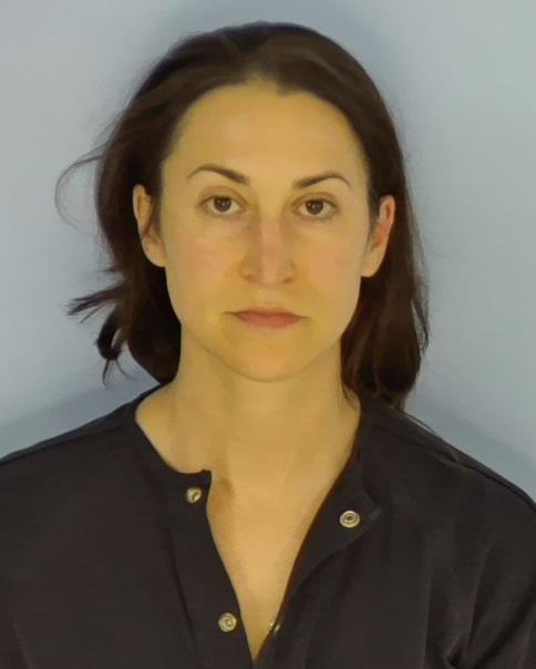 Mugshot of a woman with dark hair wearing a dark shirt.
