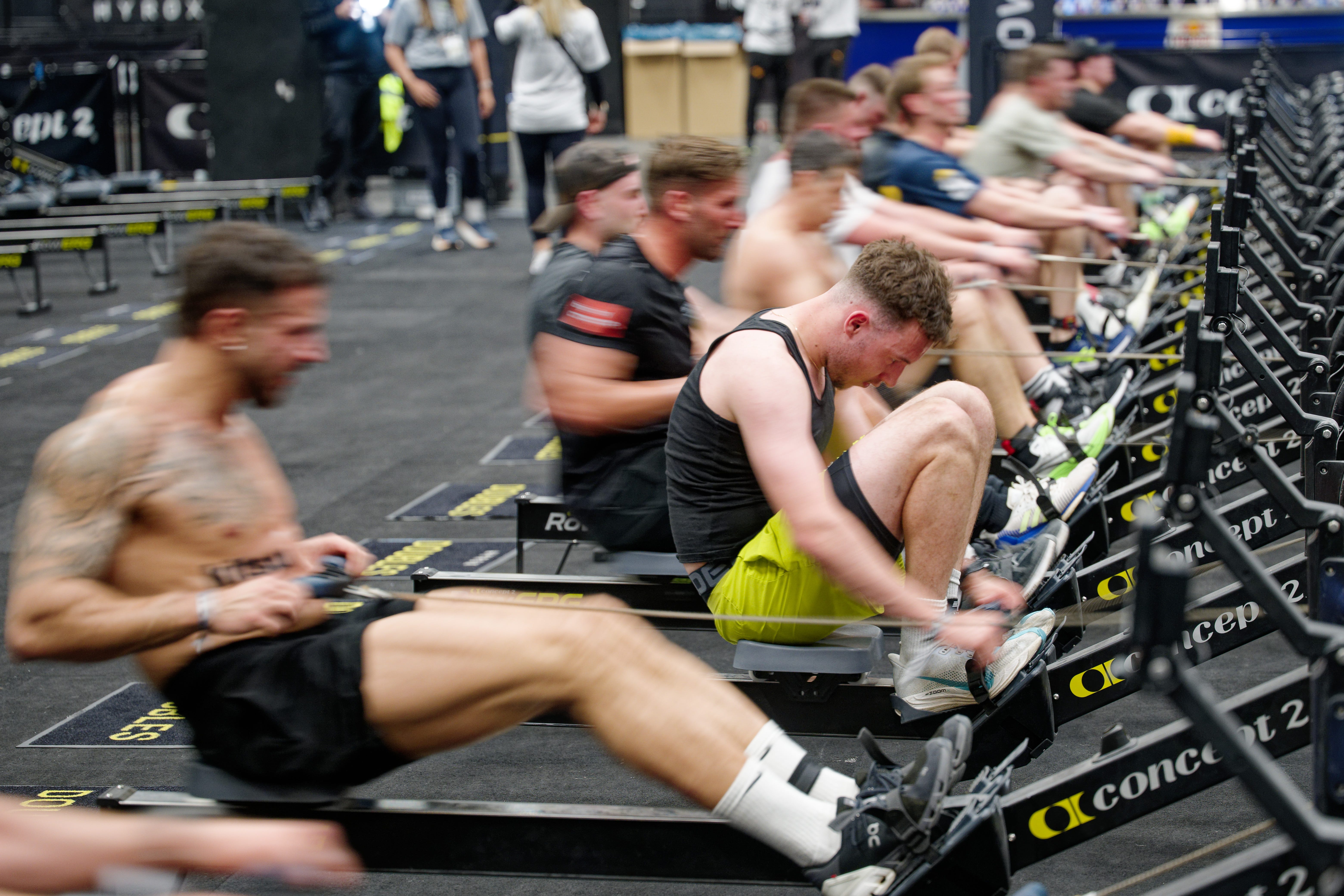 Participants row on rowing machines in a HYDROX competition at the