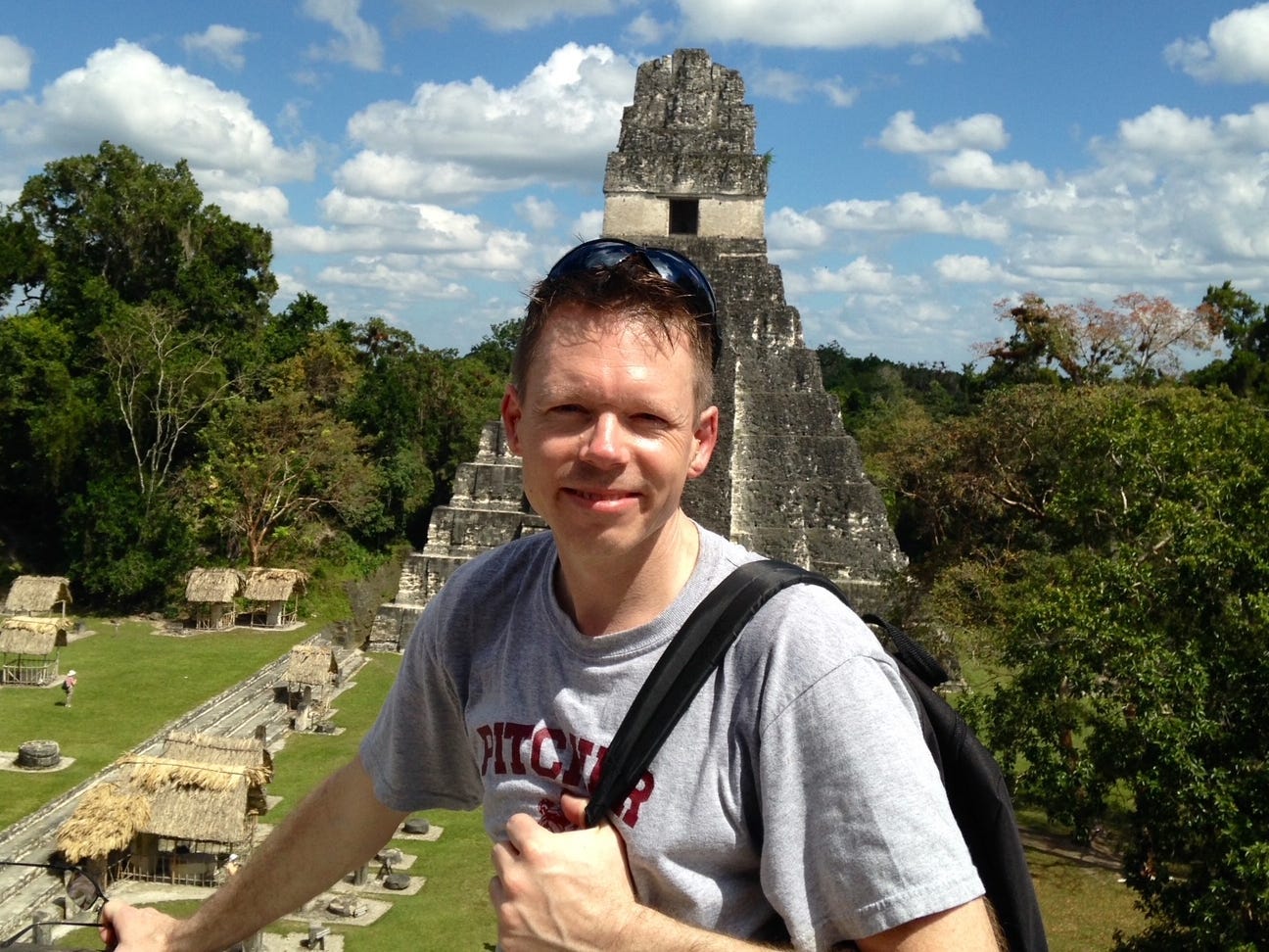 A man standing in front of Mayan ruins in Guatemala.
