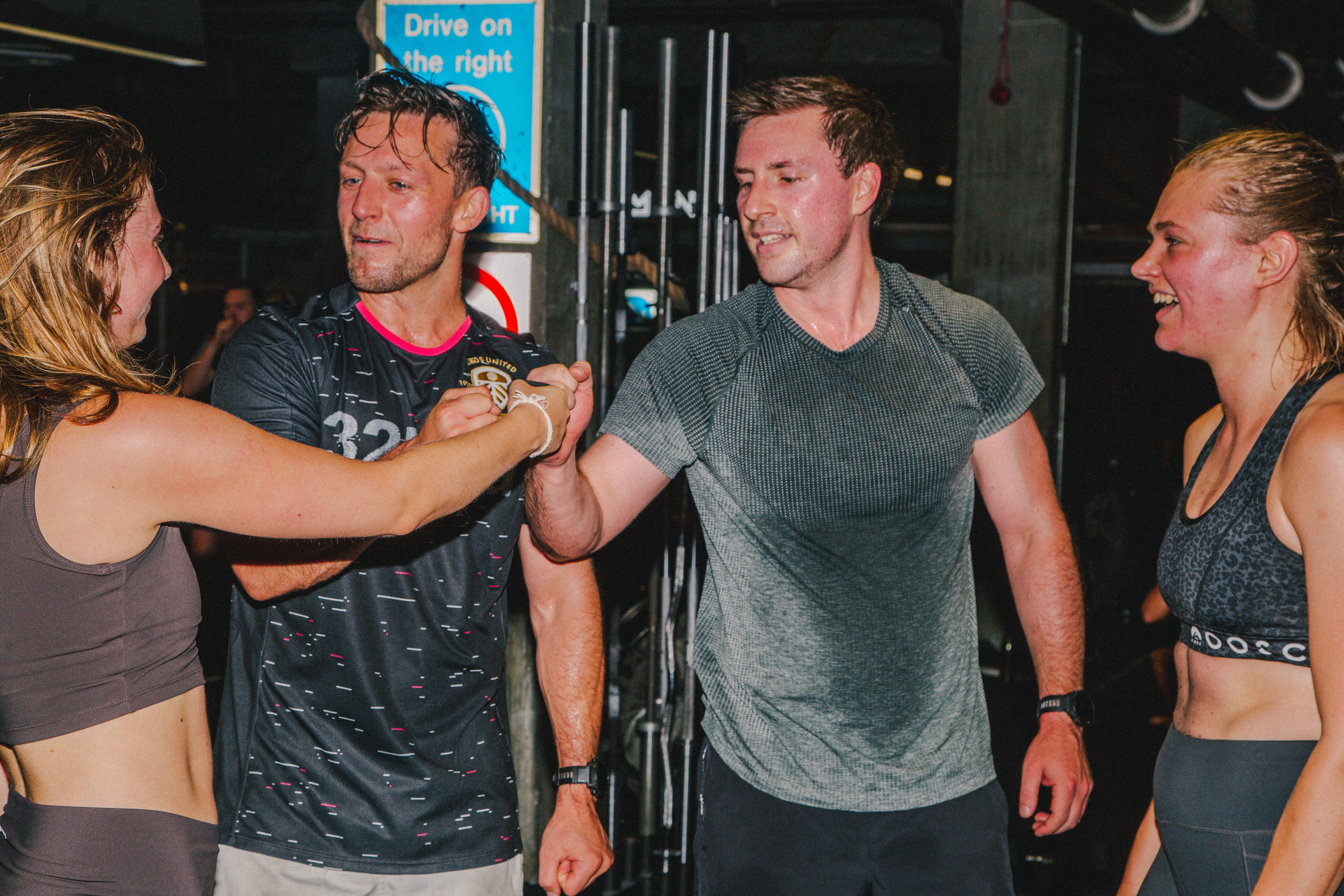 A group of people fist bump in workout gear.