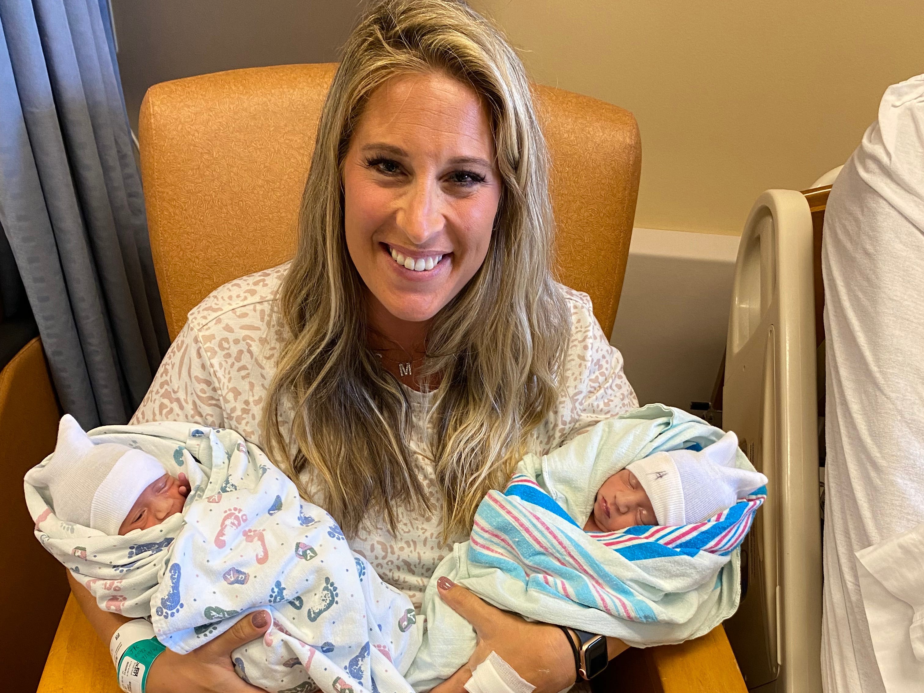 A woman holding newborn twins