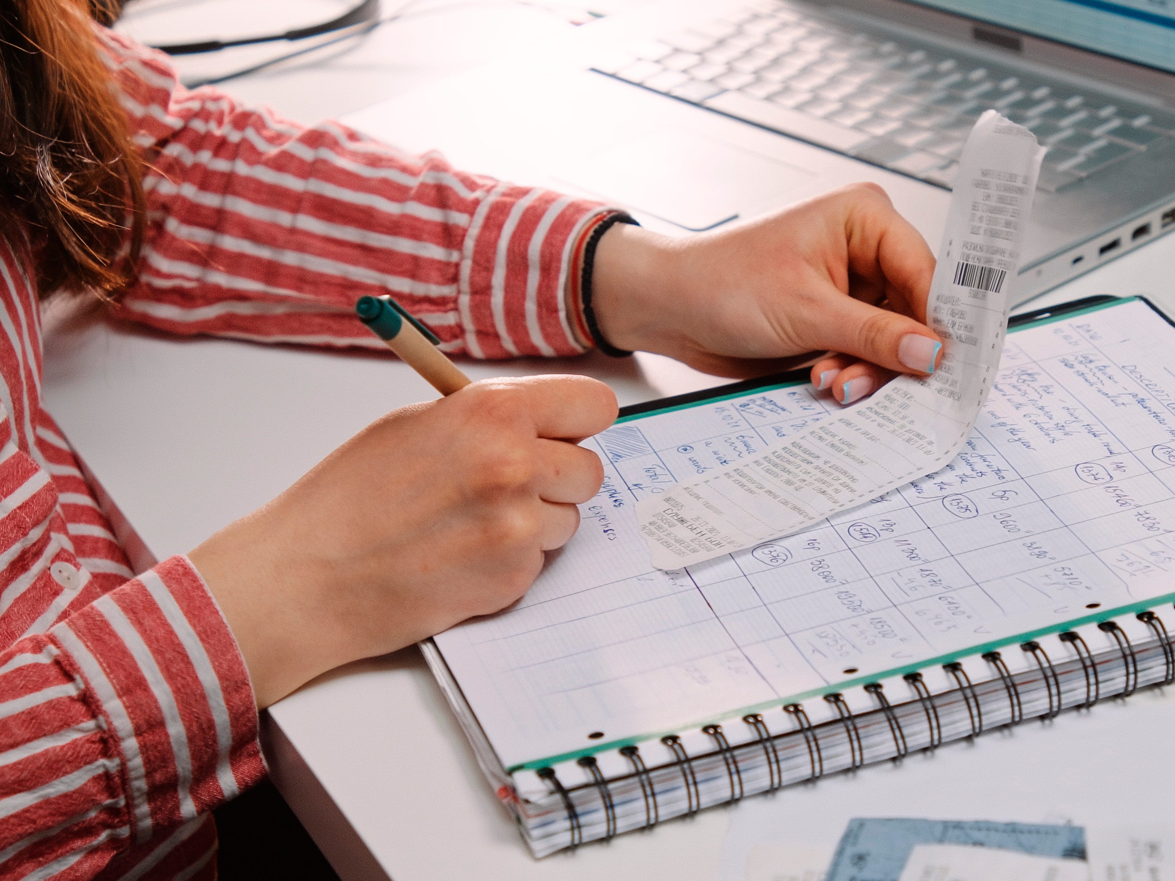 a woman looking at a reciept and a notebook