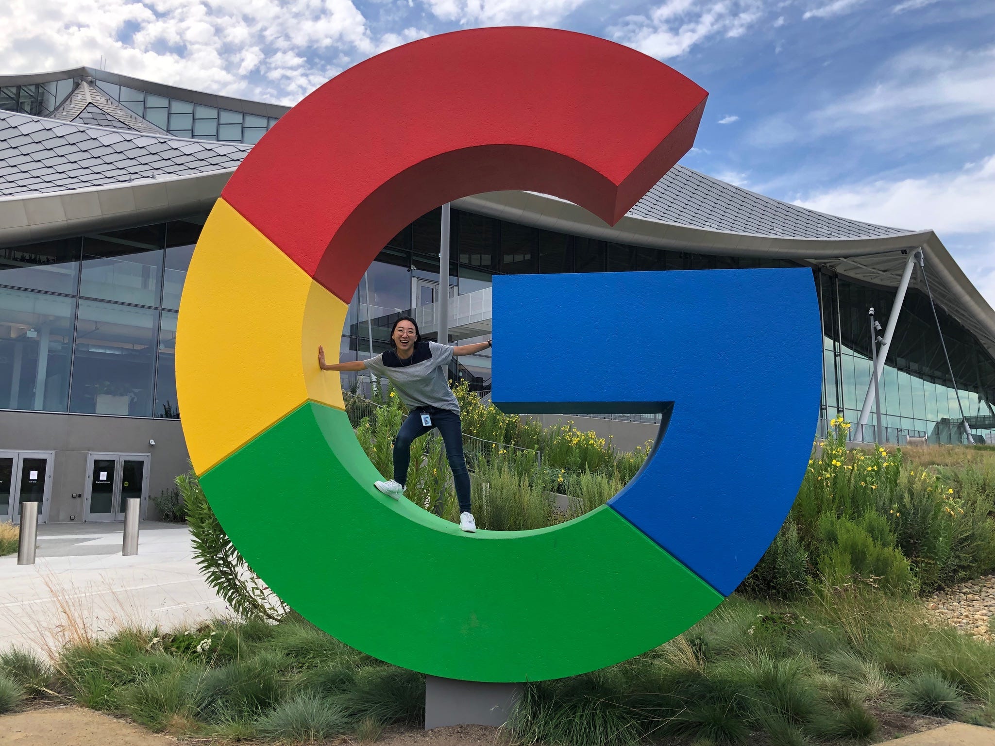 Jen Baik standing inside a big 'G' sign outside of Google's offices.