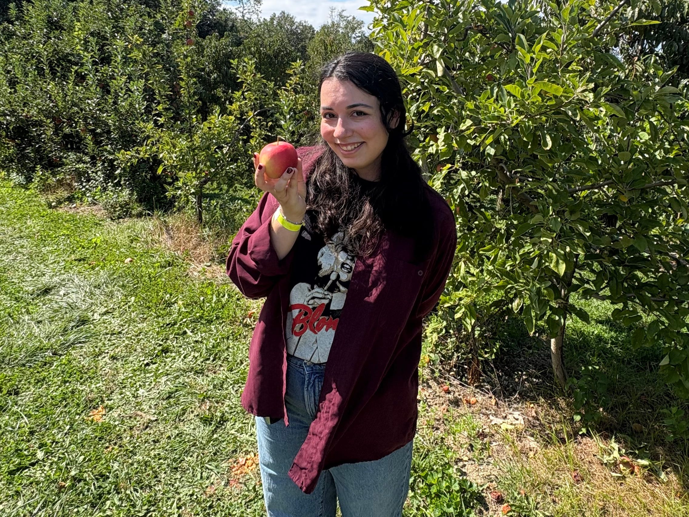 The author posing with an apple at an orchard.