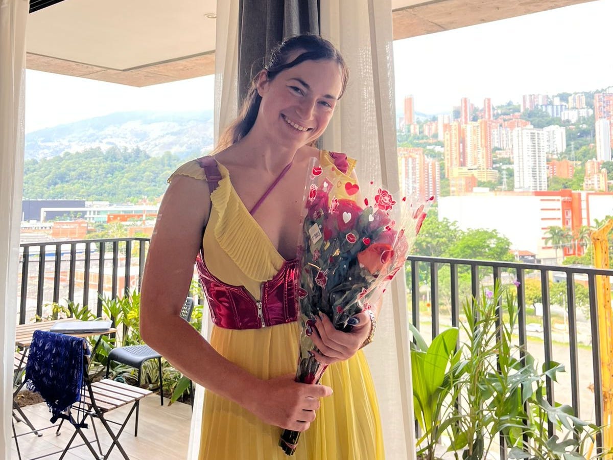 The author on her first day in Colombia in her new Airbnb, holding a bouquet of flowers.