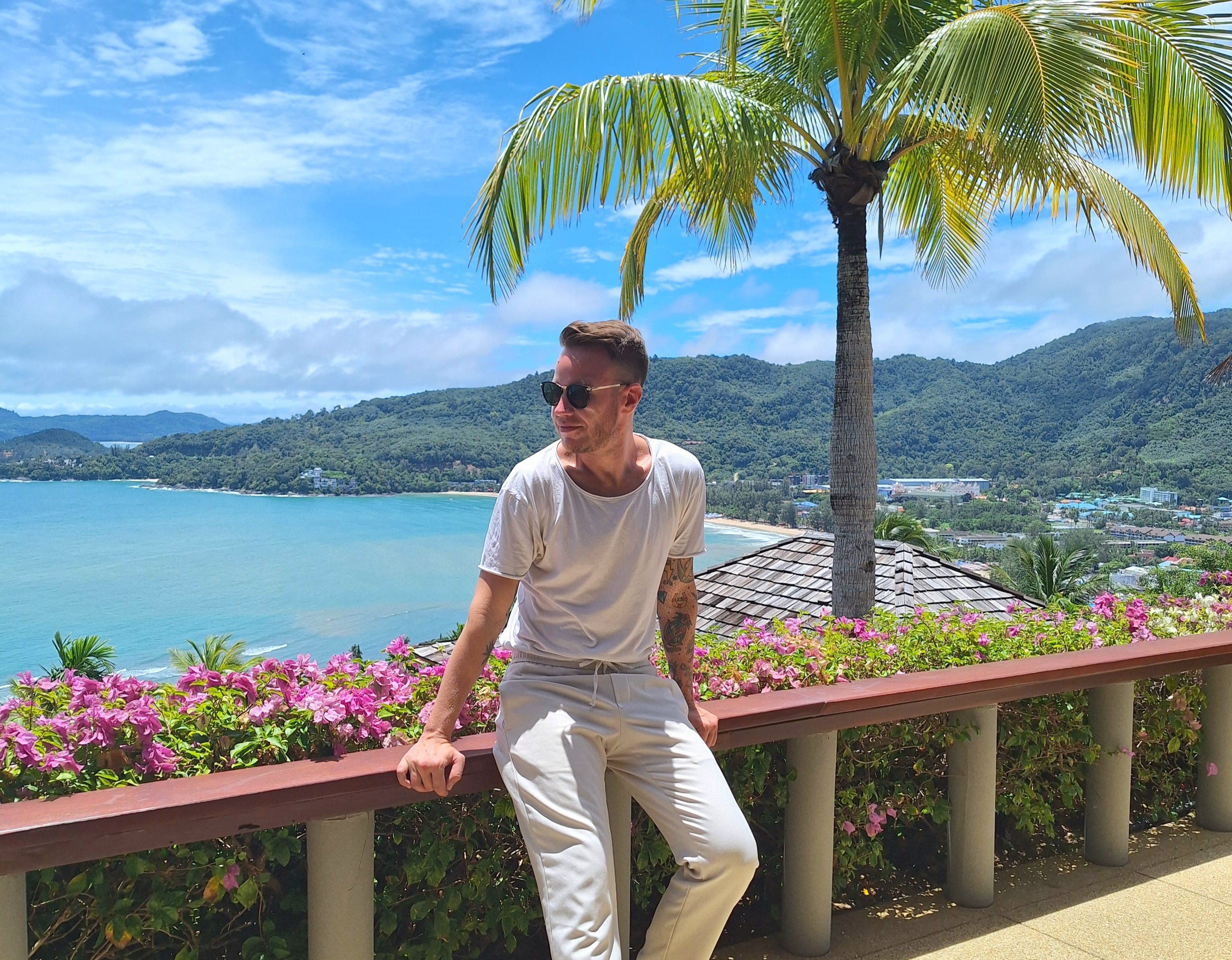 Andre Neveling standing with the sea and palm trees in Phuket, Thailand.