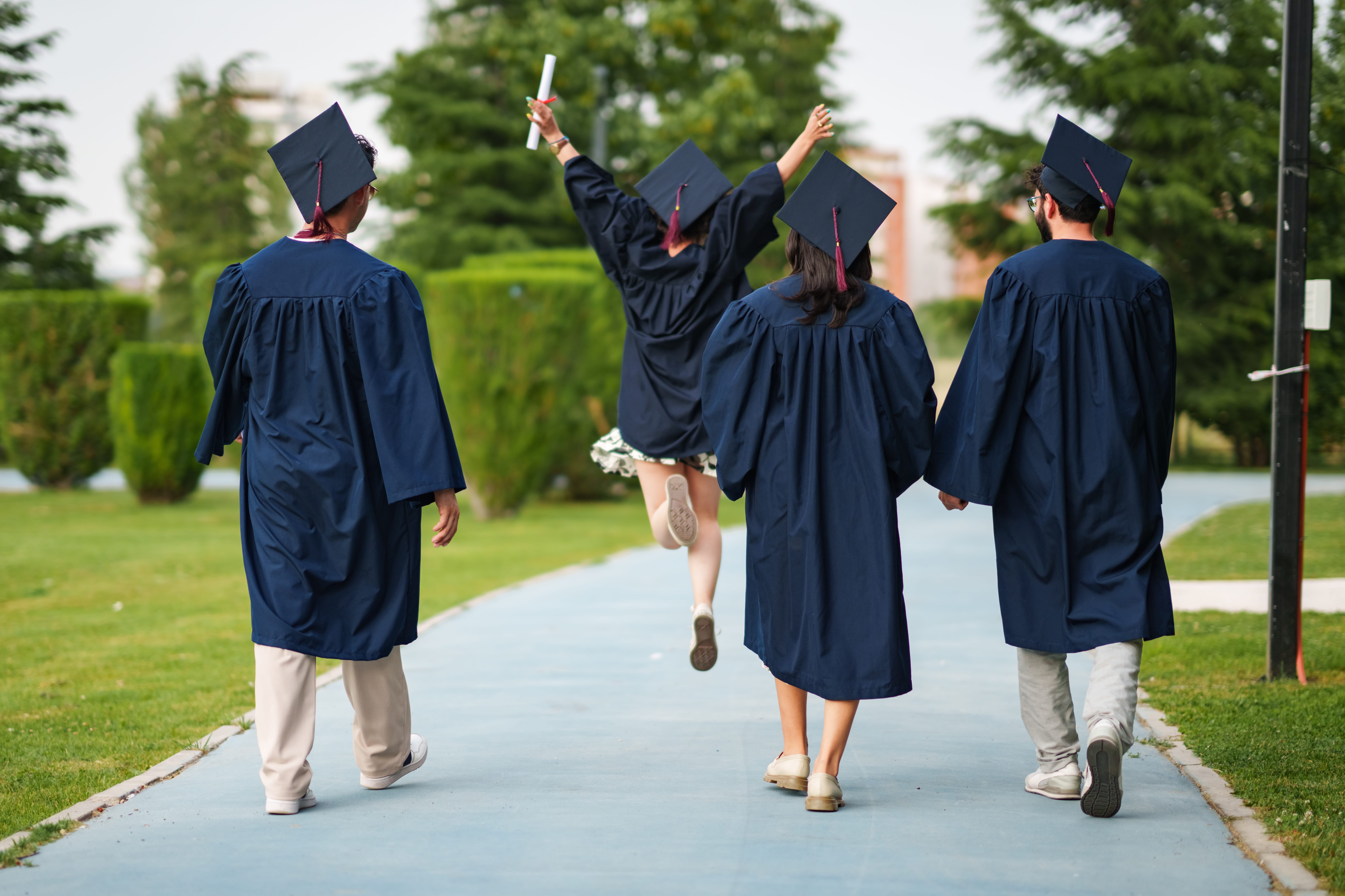 Young adults celebrating their graduation in the campus.