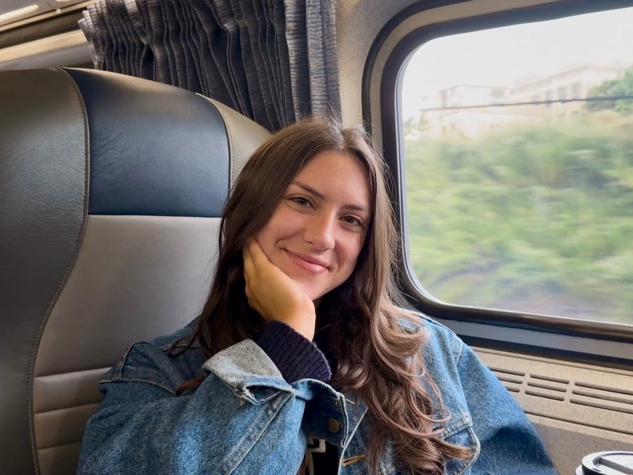 Amanda smiling near a window on Amtrak.