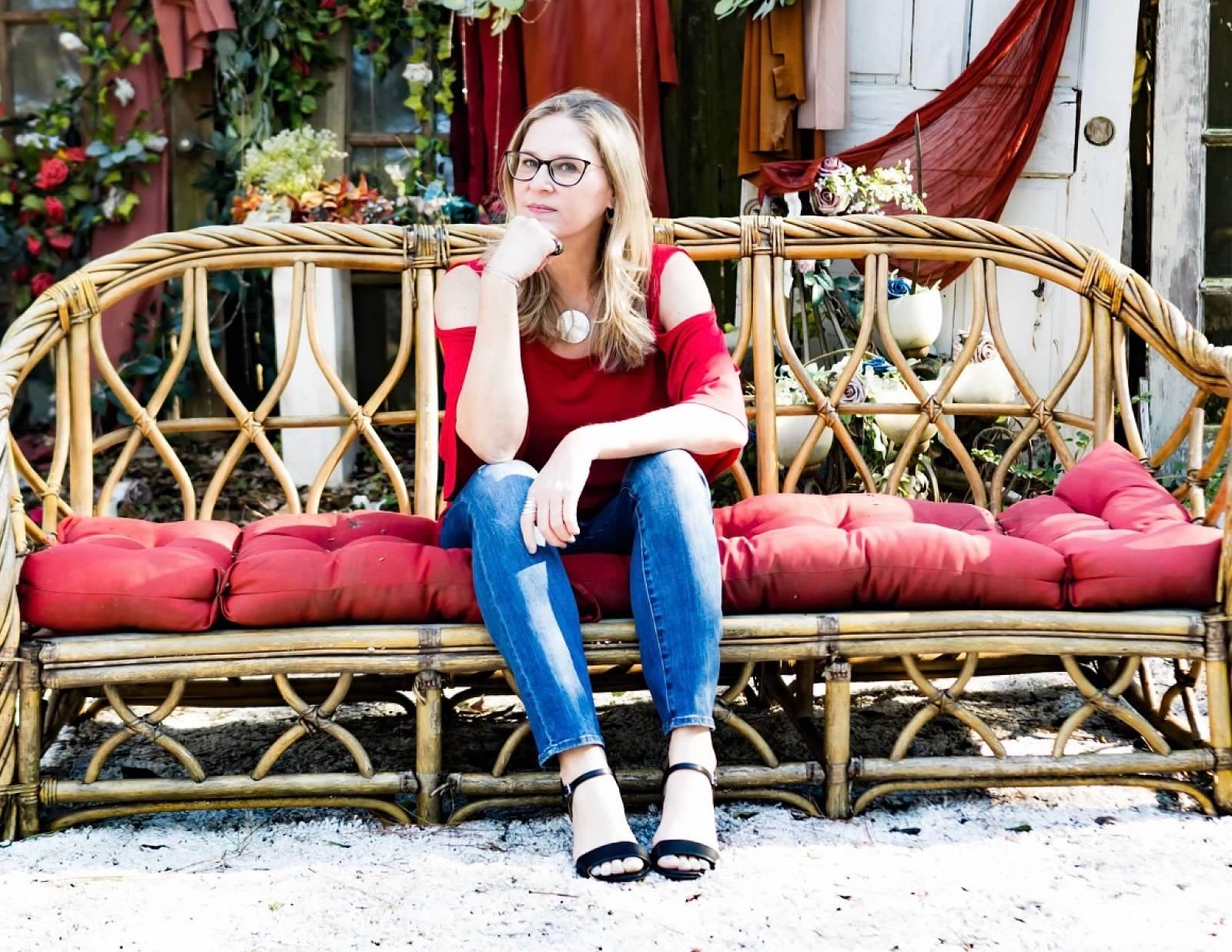 Author Heather Sweeney poses on a couch outdoors.