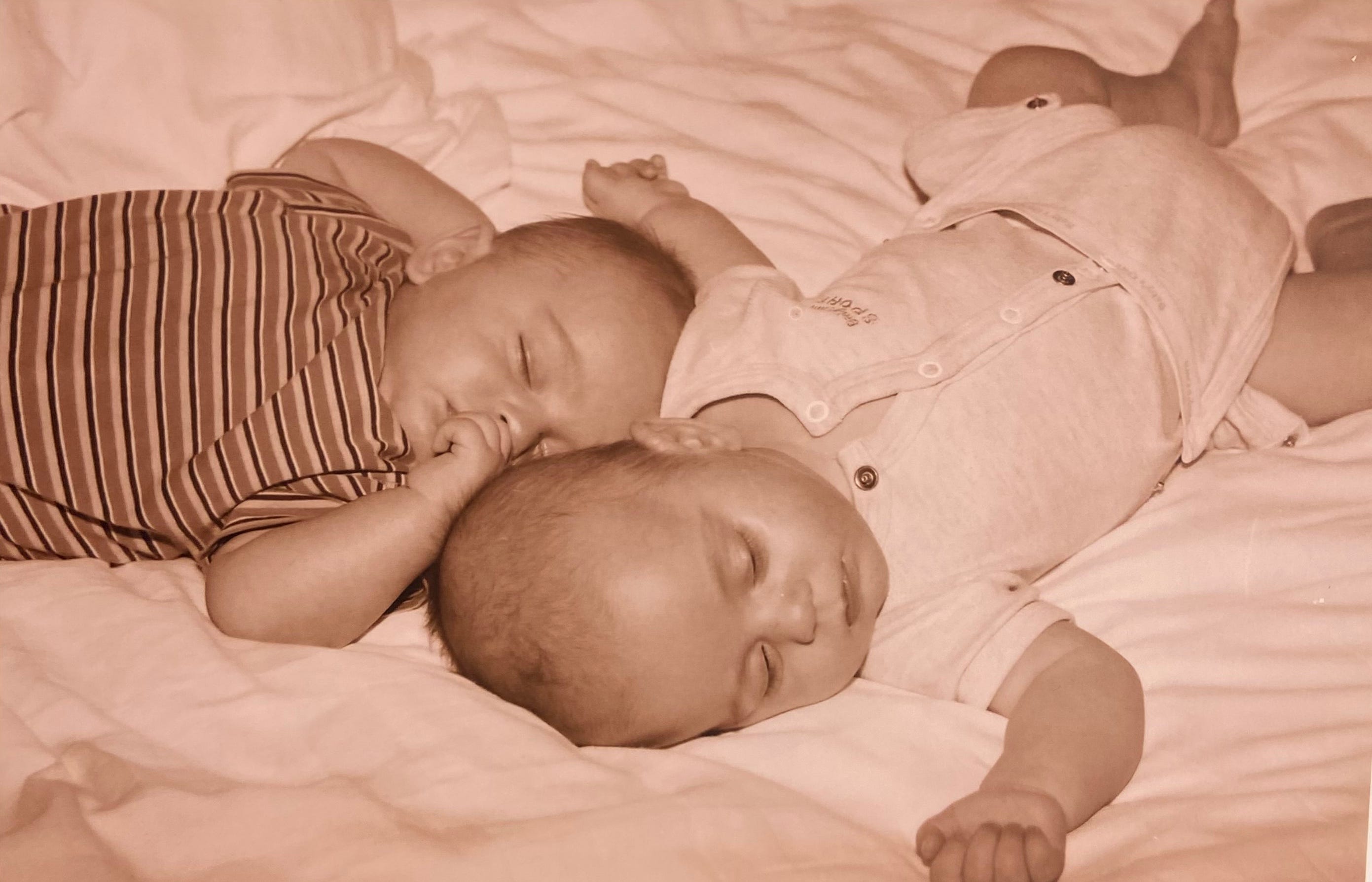 Twins sleeping on a bed