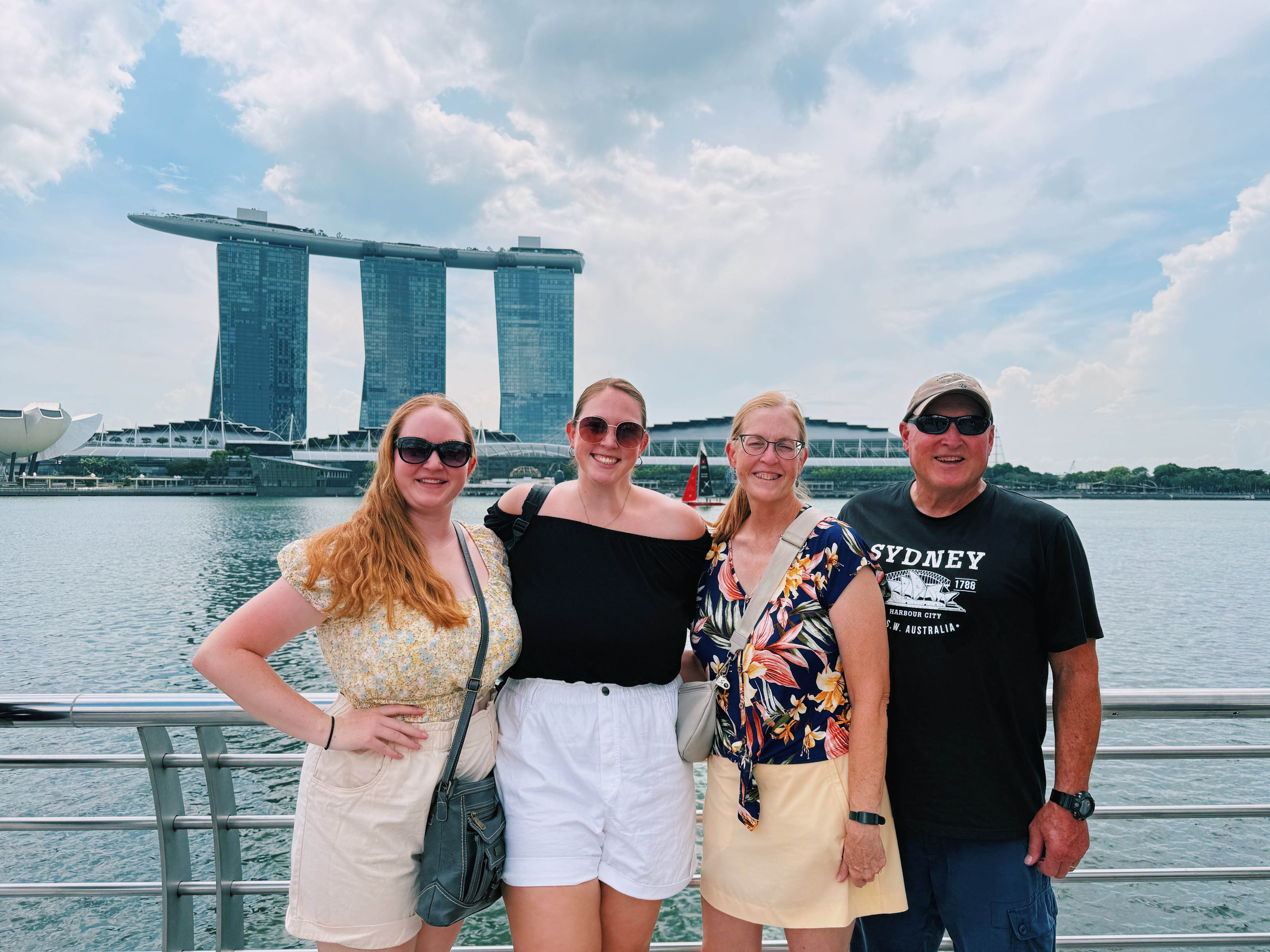 Author Allie Hubers with her sister, parents smiling in front of water