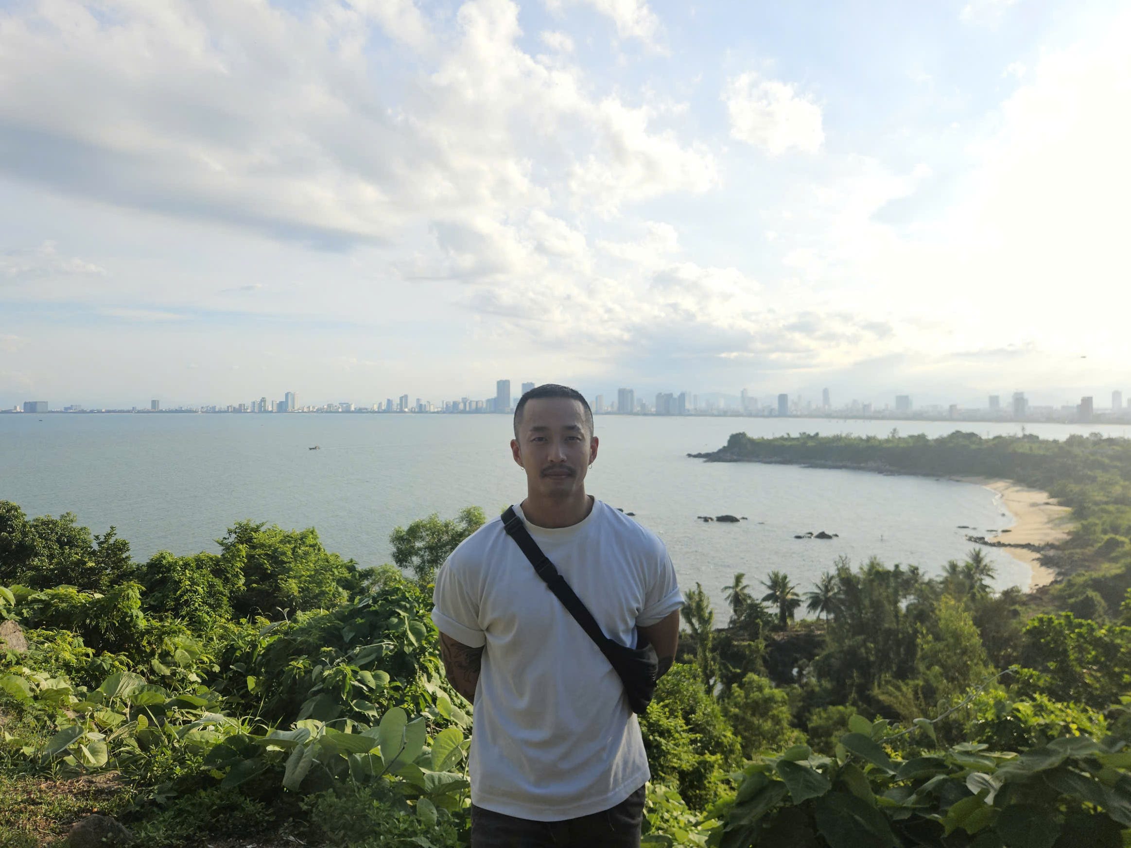 A man standing on top of a hill overlooking the ocean