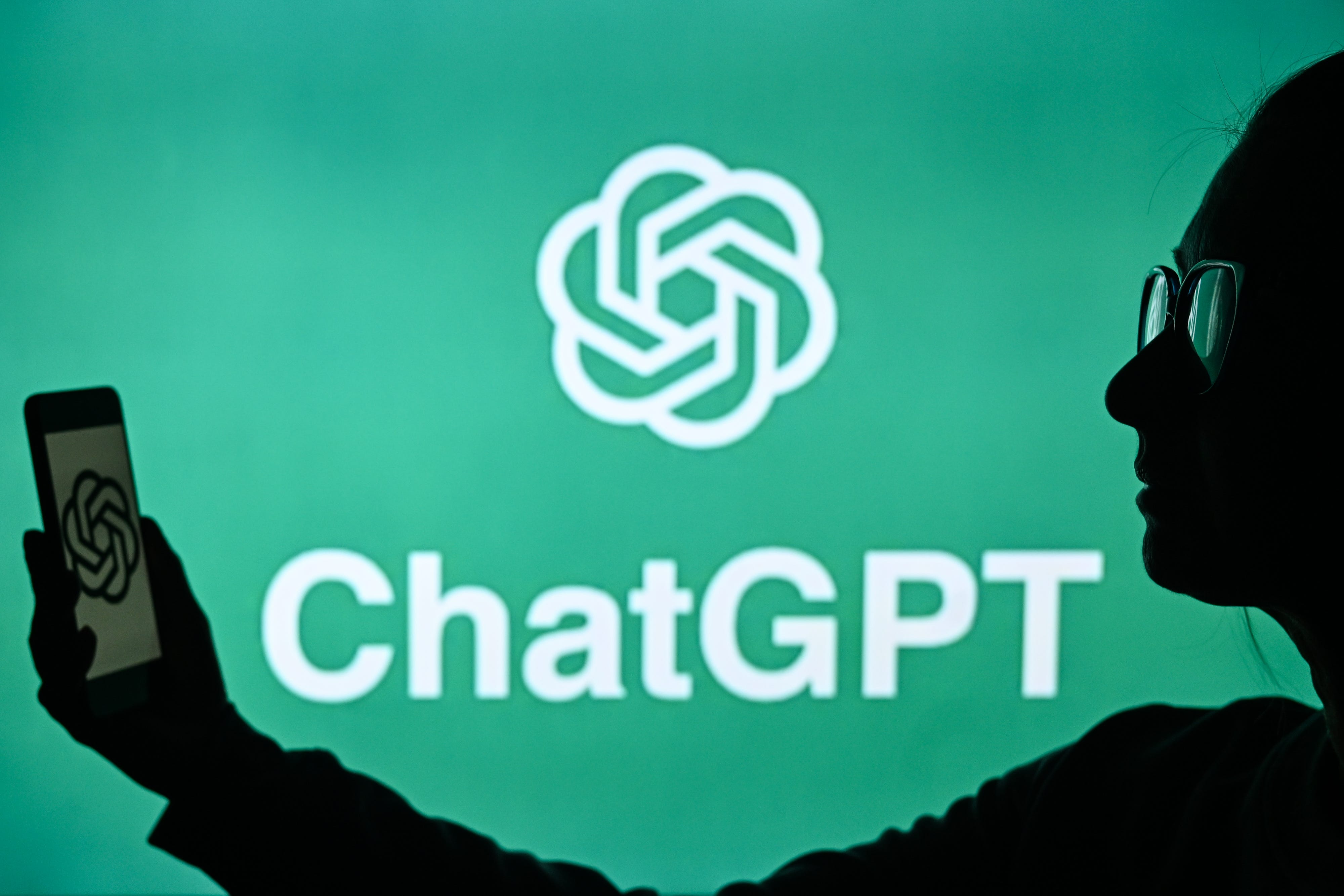 Person standing in front of ChatGPT logo
