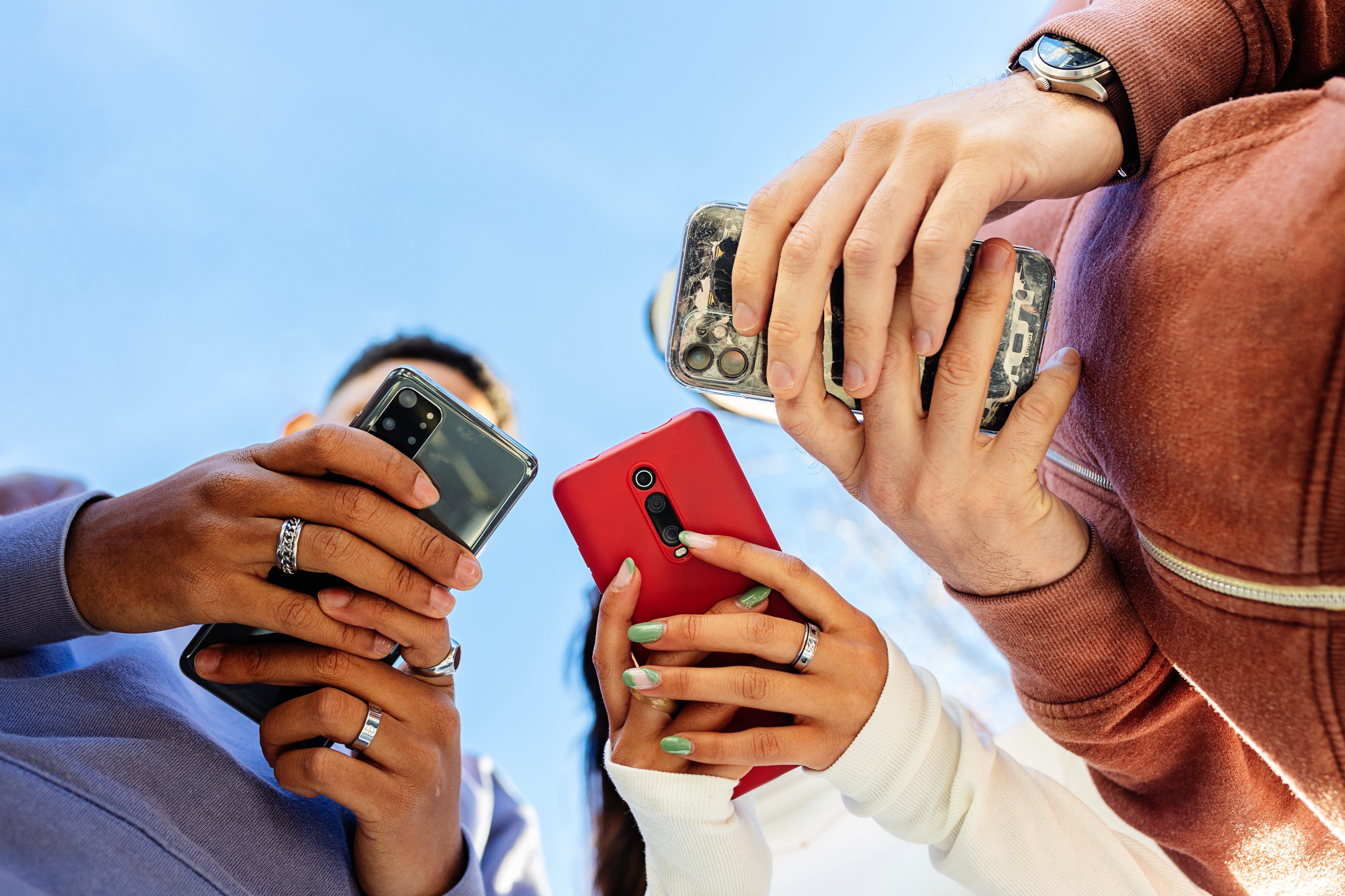 Adults hold their phone in their hands.