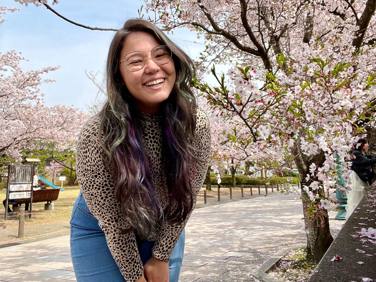Author Ashley Probst smiling with cherry blossoms