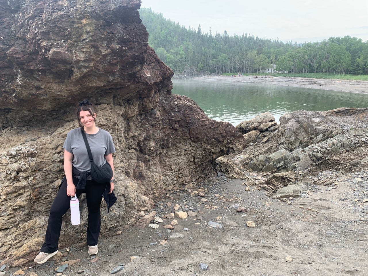 Author Mira Miller standing next to rock formation in park