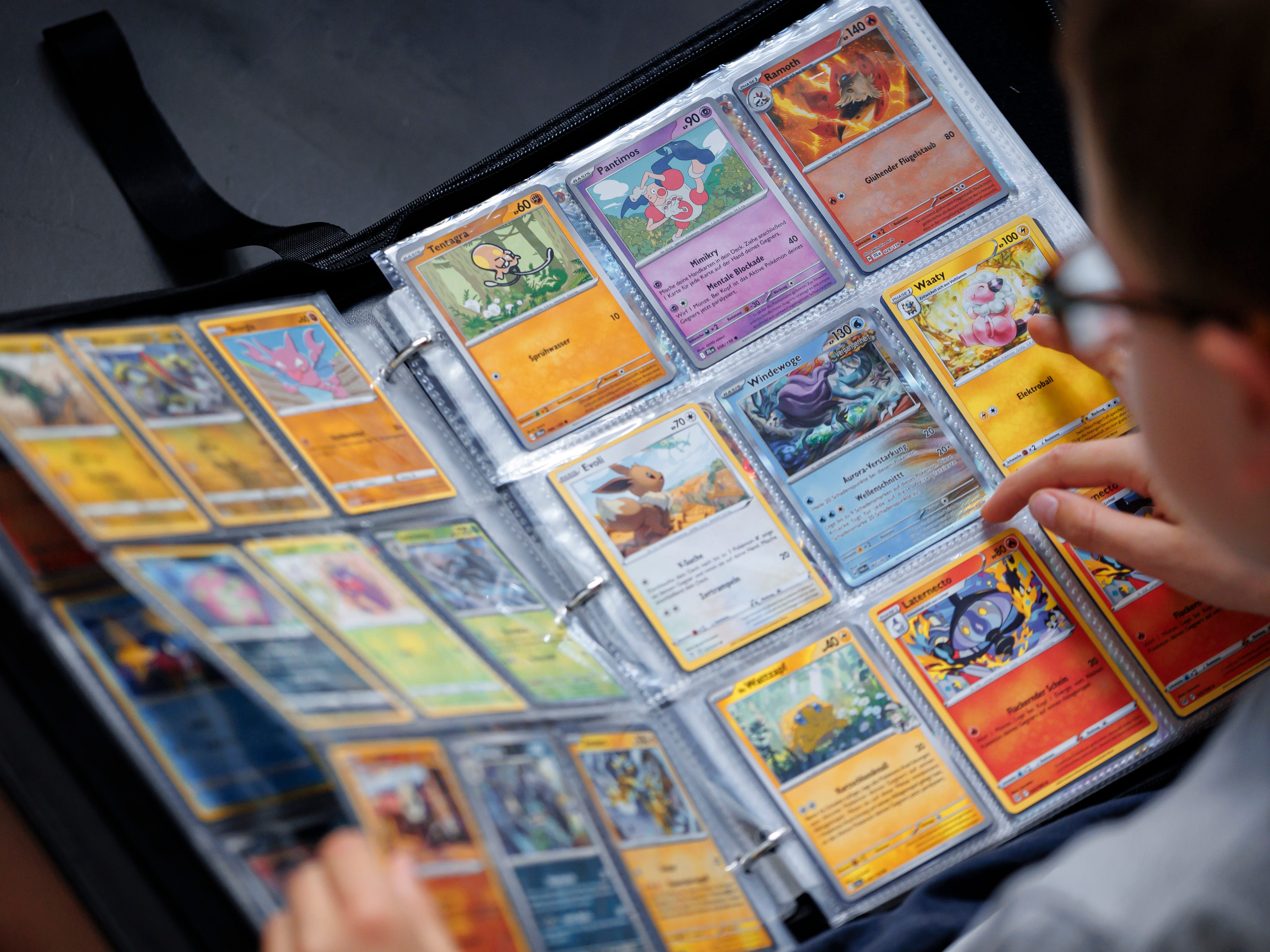 a boy looking at his Pokémon cards