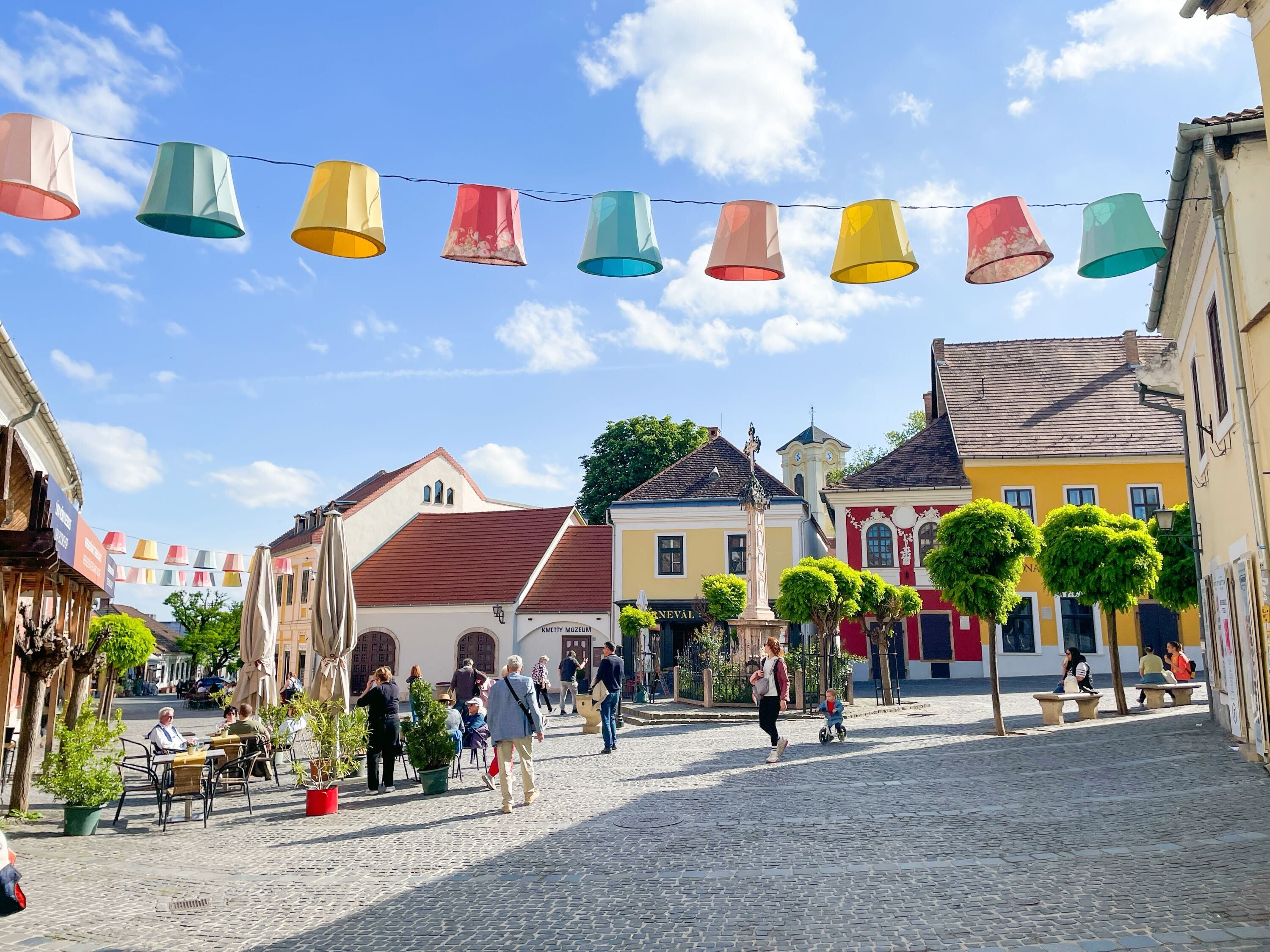 A wide shot of Szentendre, Hungary, with colorful decorations hanging above the street.