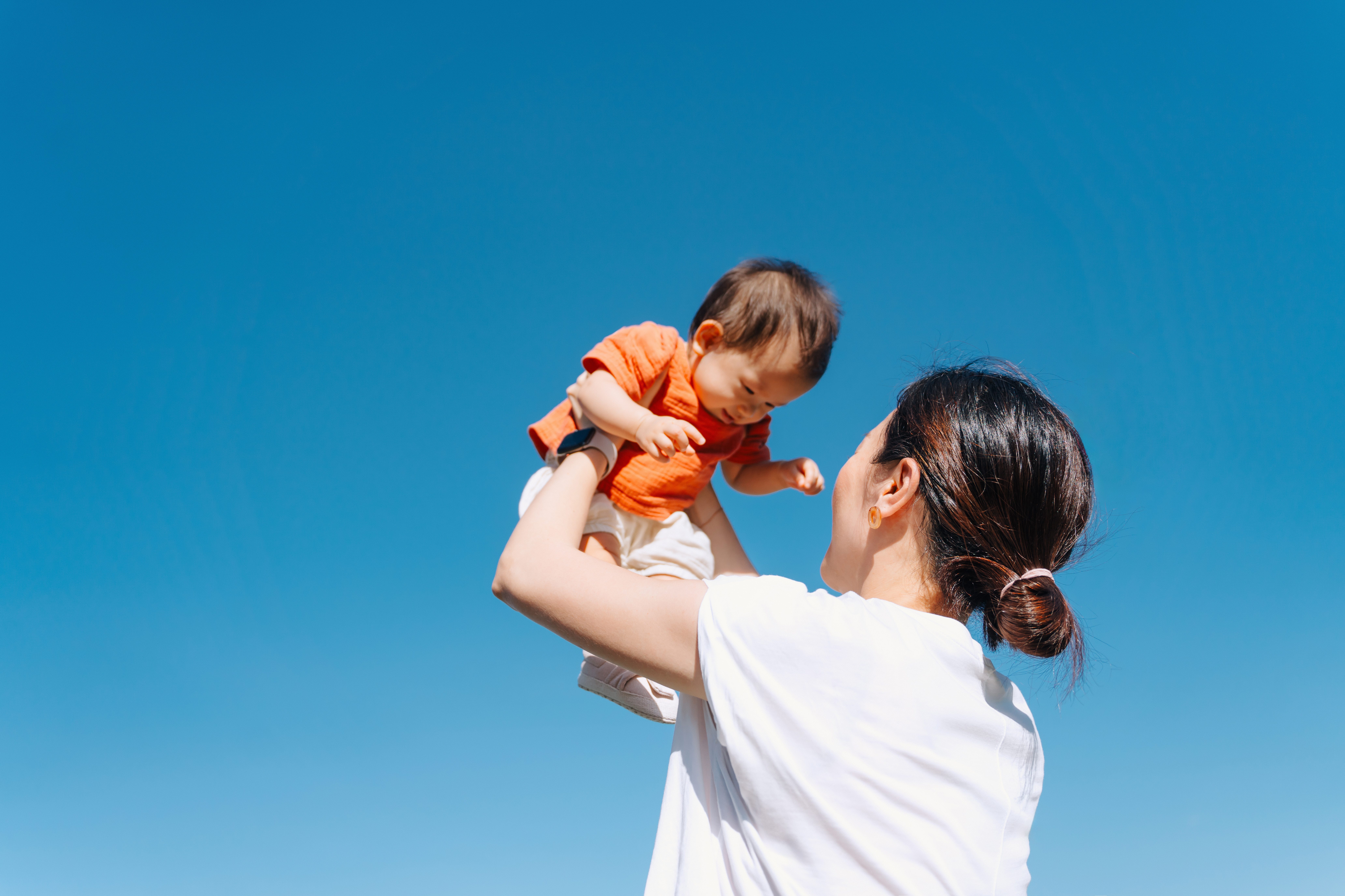 A mother holds her baby in her arms.