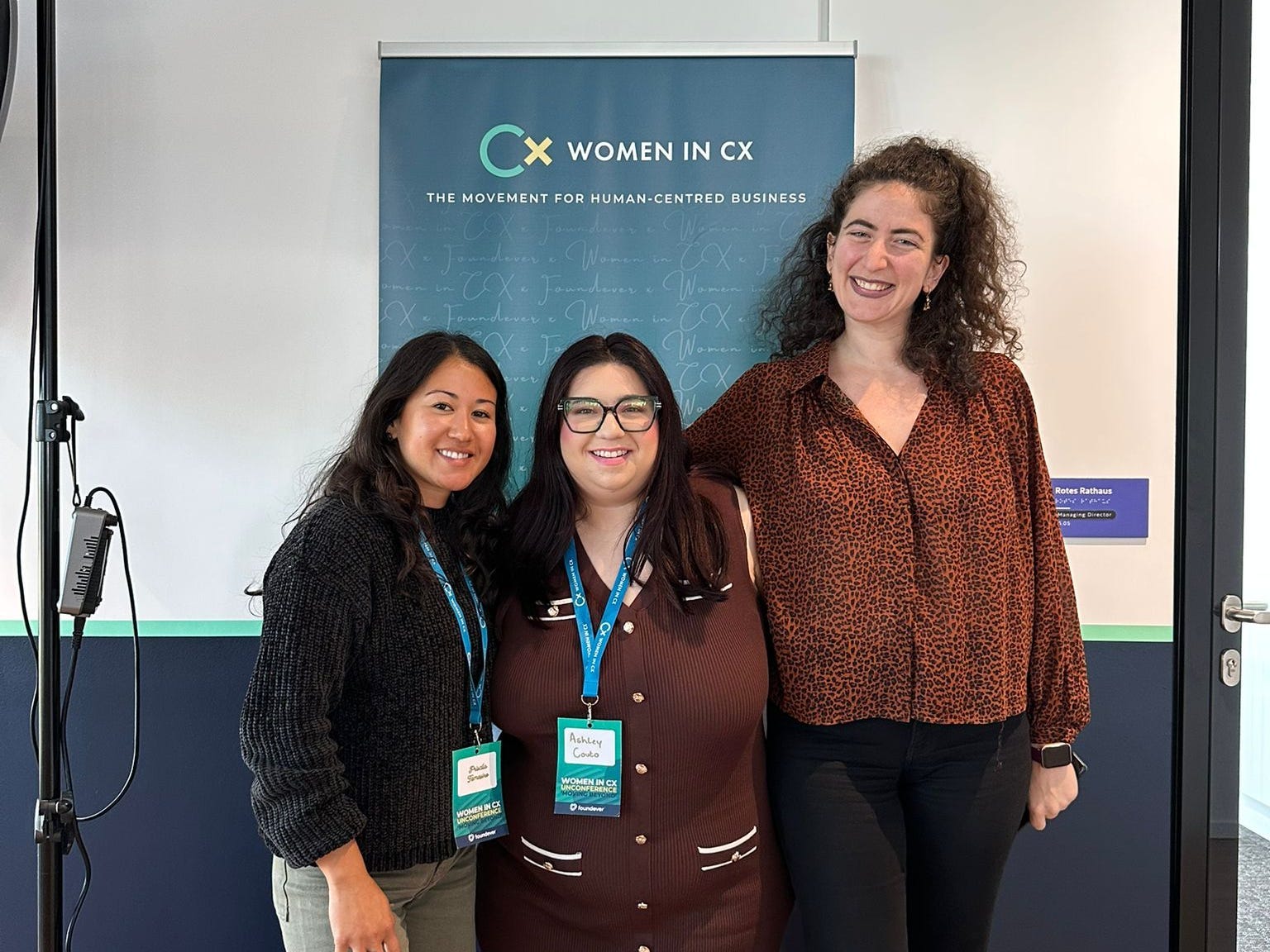 three women pose for a photo at a conference
