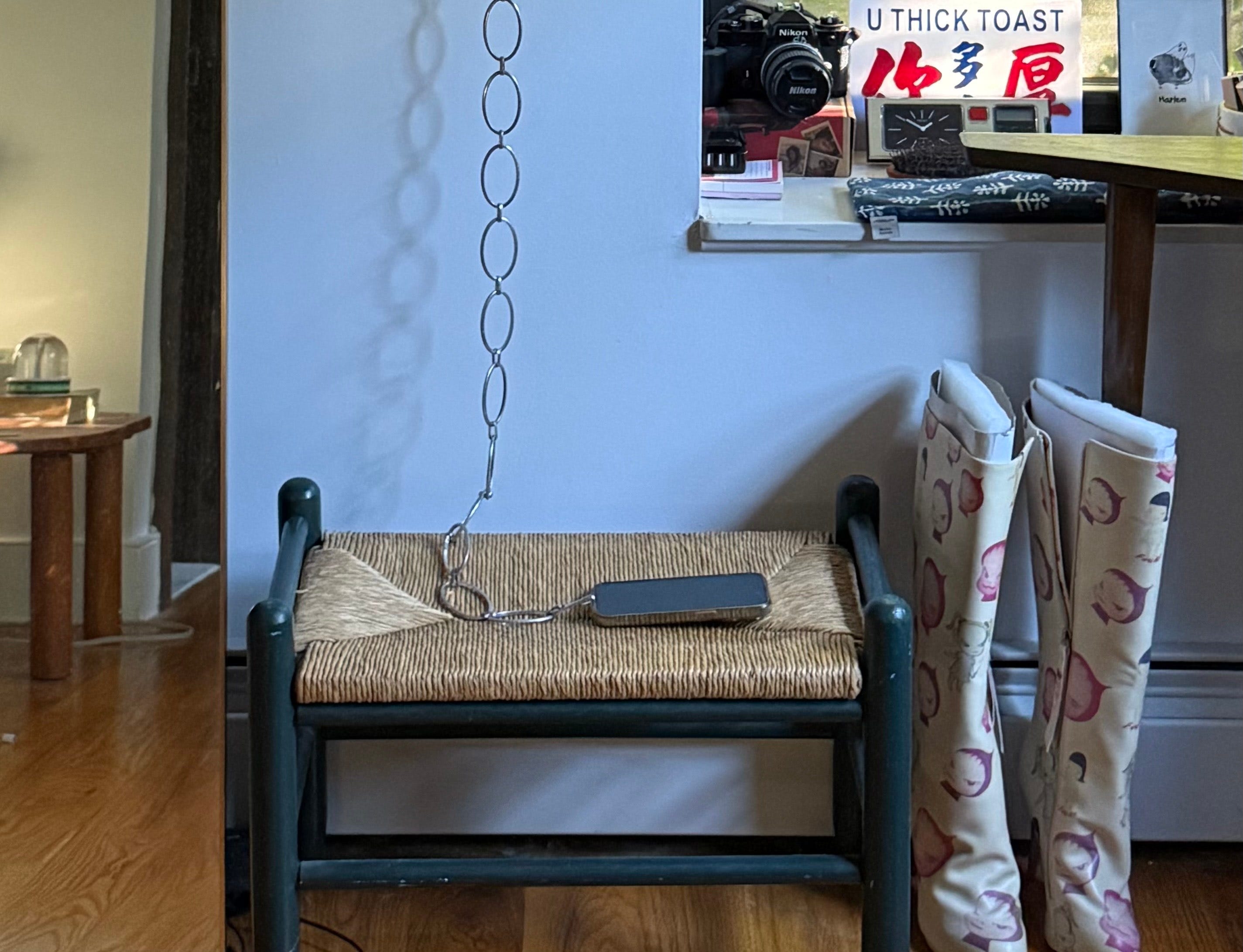 Phone chained to wall and sitting on bench.