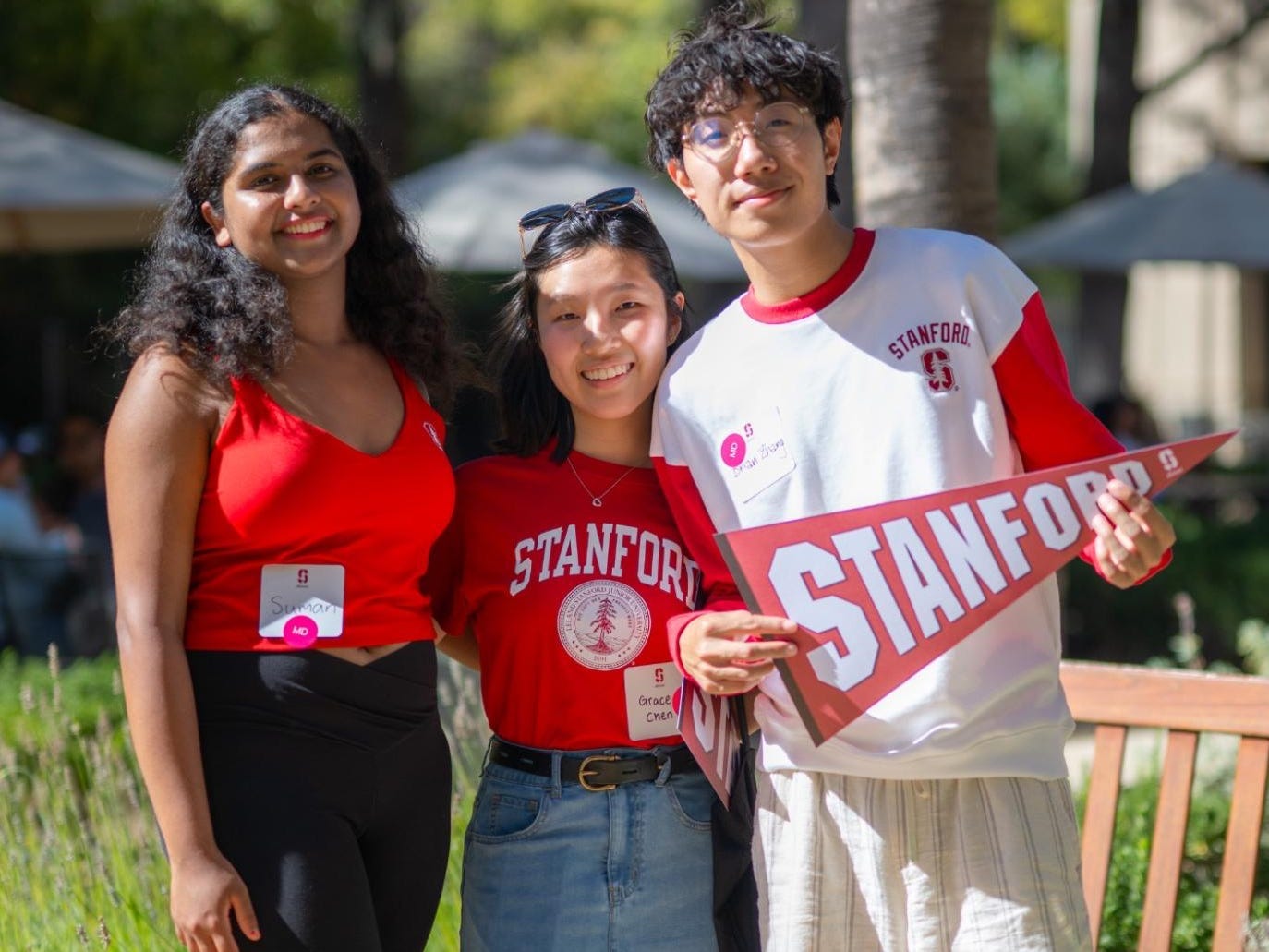 Brian Zhang with two fellow students holding a stanford flag