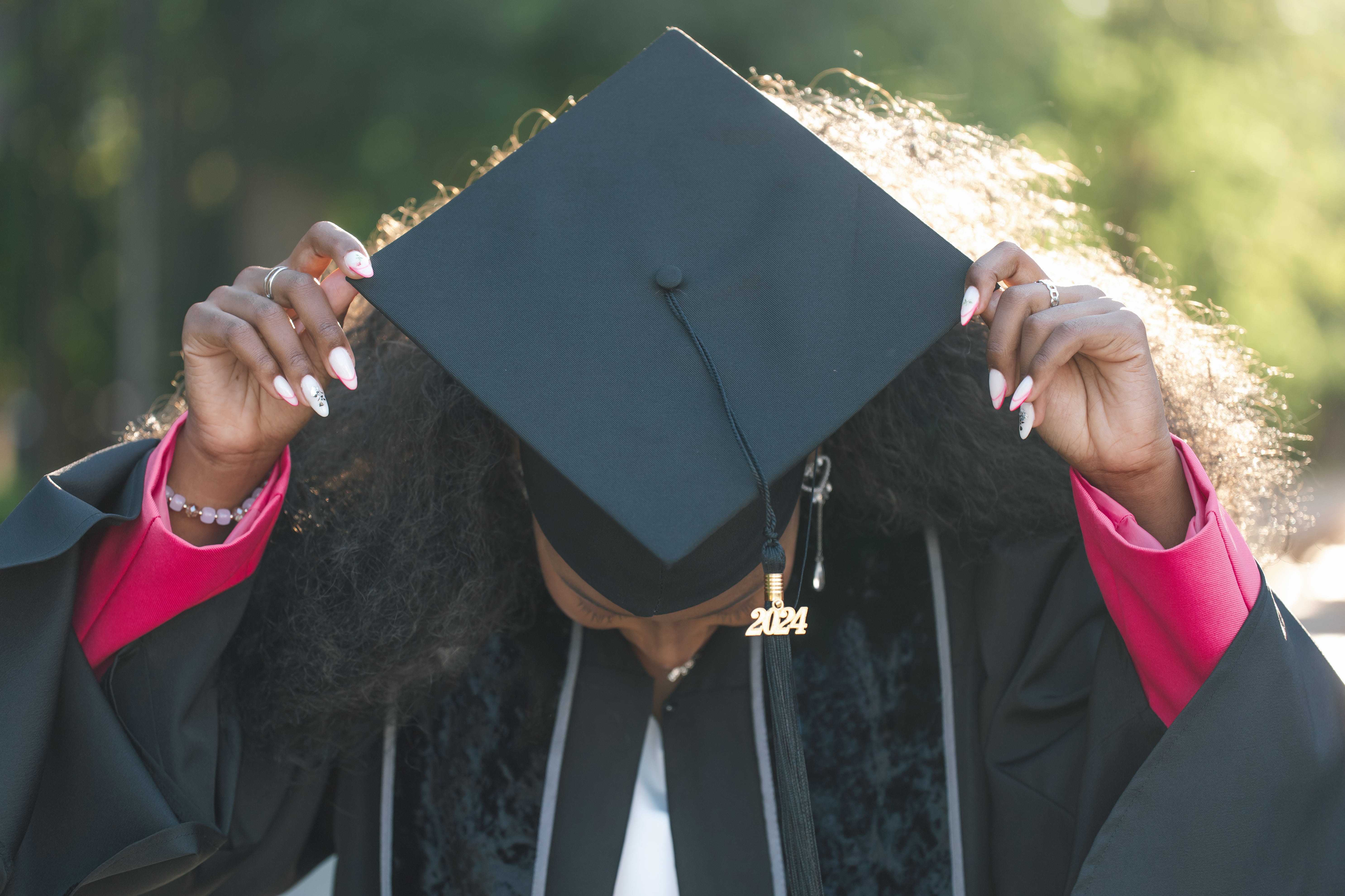 a woman in graduation cap and gown looking down