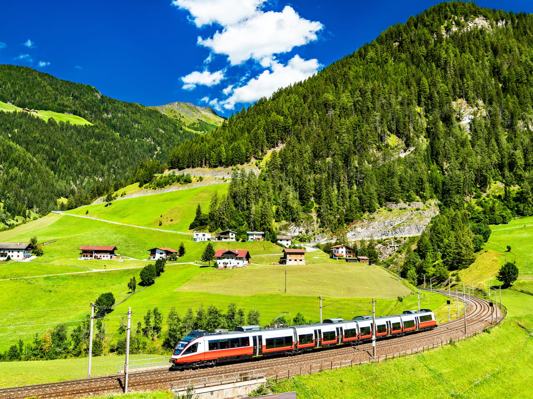 A train riding through green hills in Austria.