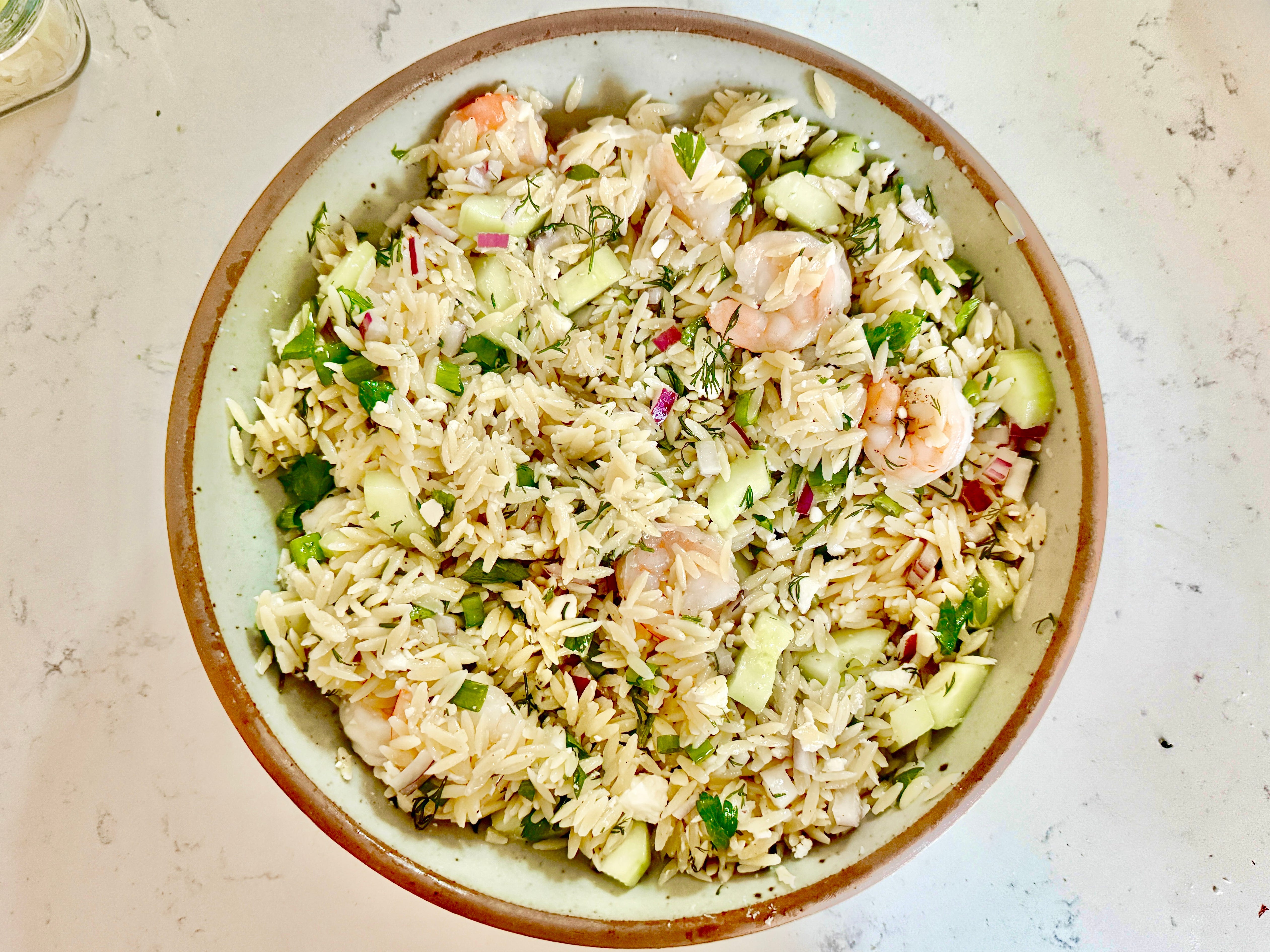 A bowl of roasted shrimp and orzo.