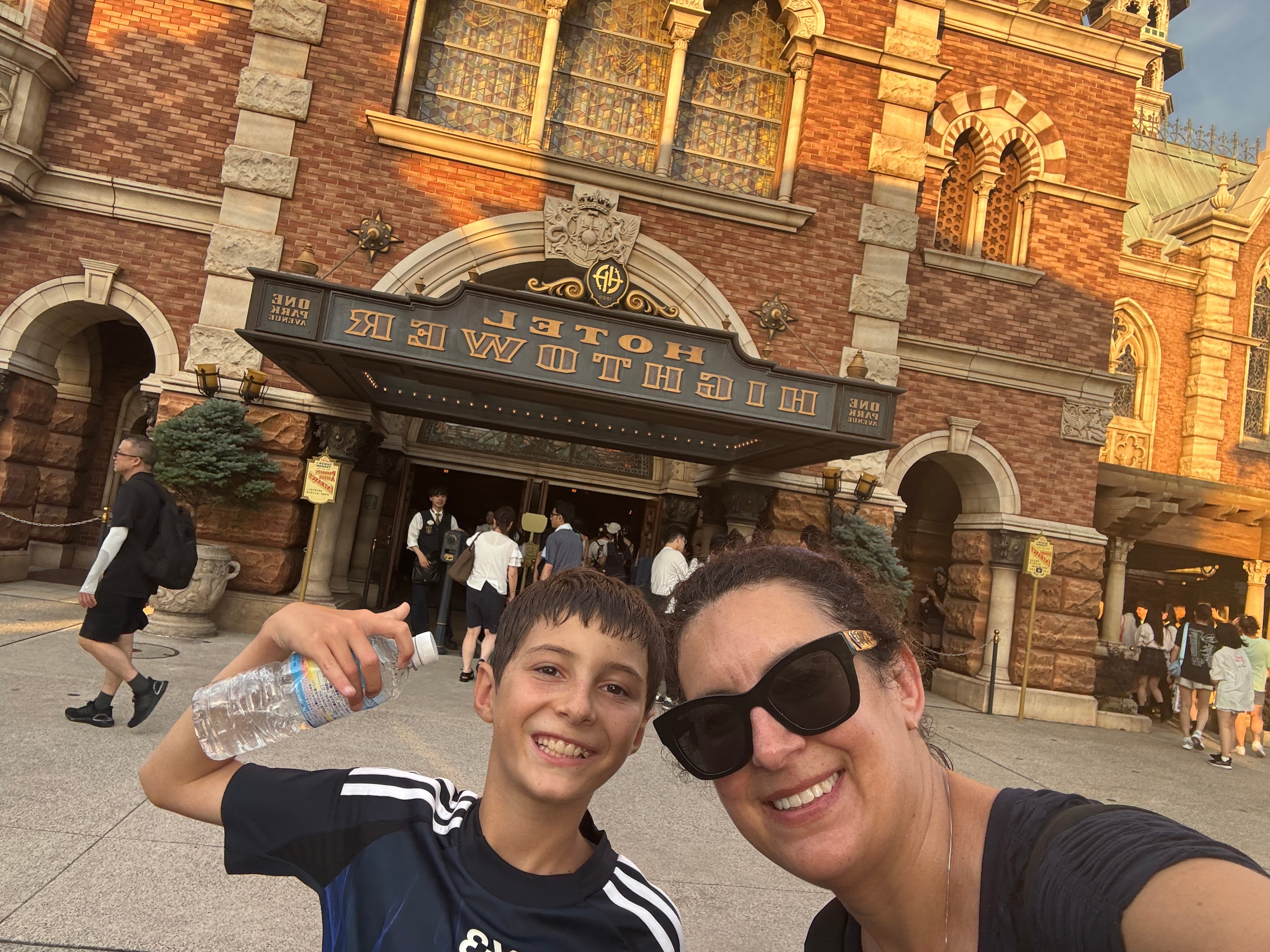 The author poses with her son outside of the Tower of Terror attraction at Tokyo DisneySea in Japan.