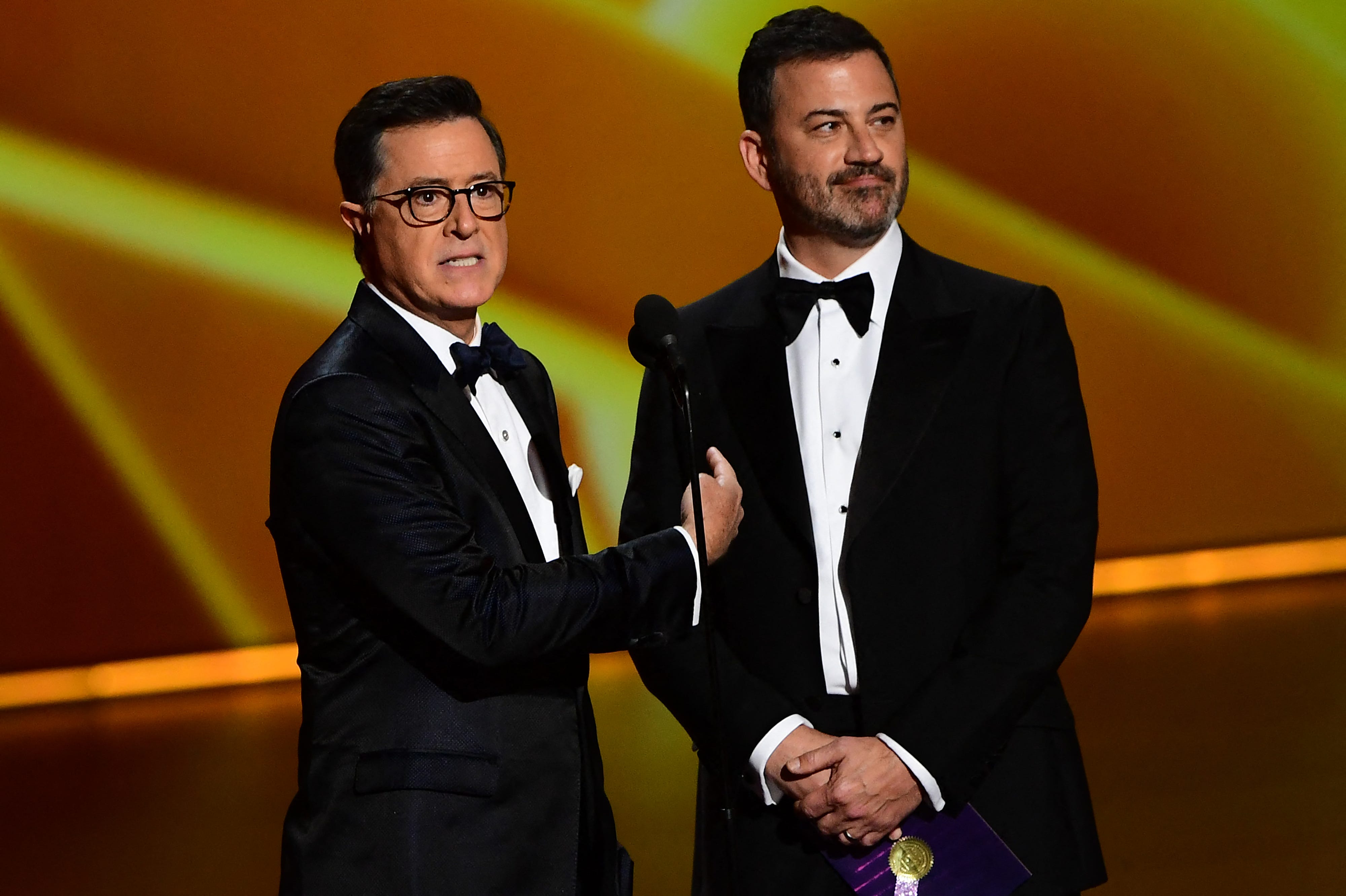Stephen Colbert (L) and Jimmy Kimmel speak onstage during the 71st Emmy Awards at the Microsoft Theatre in Los Angeles on September 22, 2019.