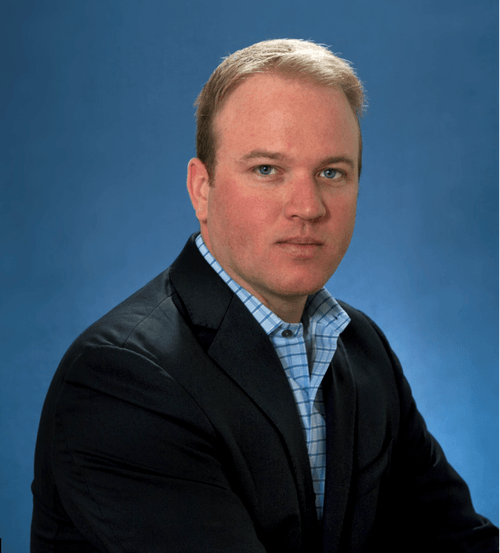 Kyle Mowitz in a black blazer and blue plaid shirt.