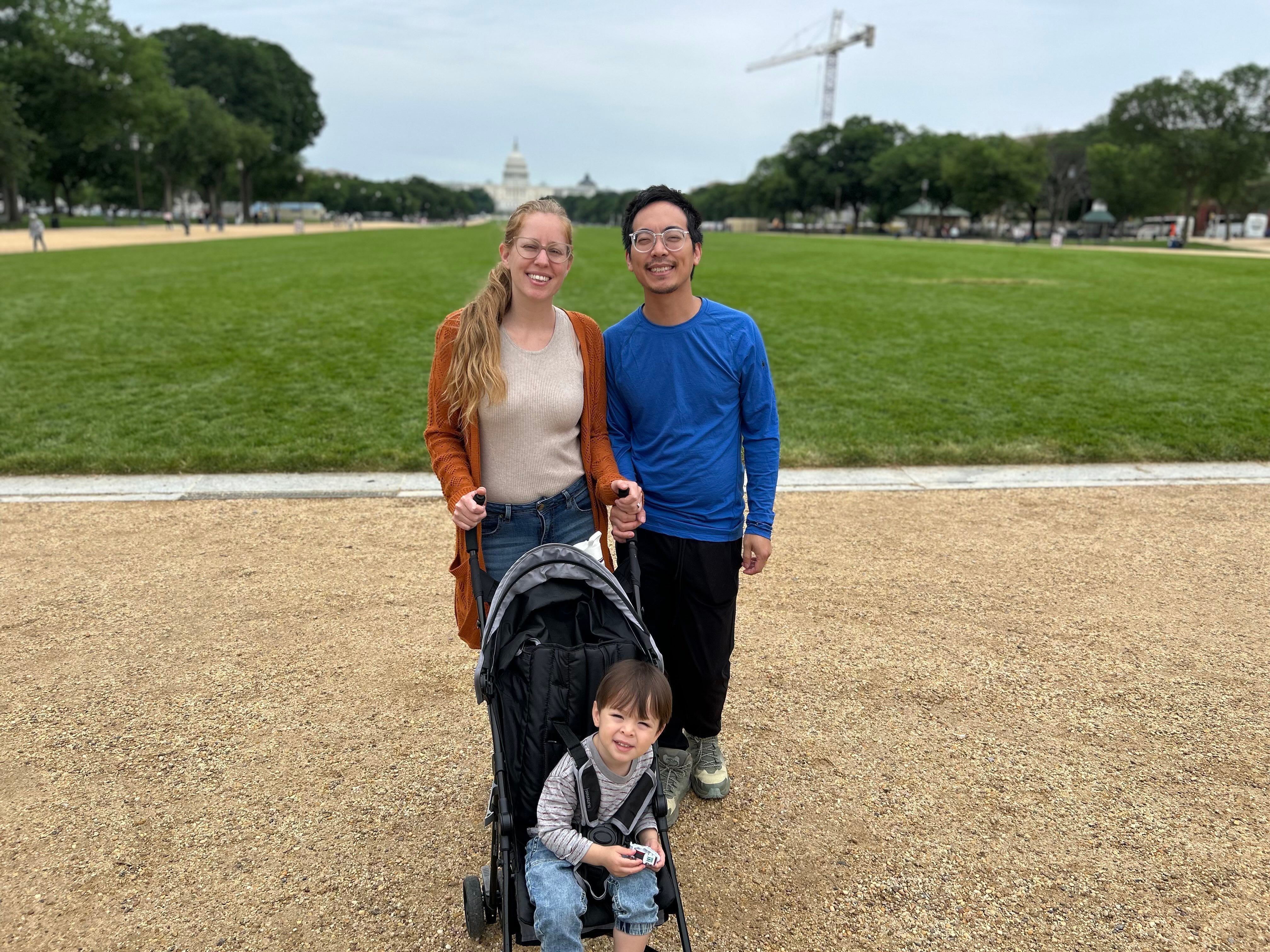 Husband and wife stand with a child in a stroller