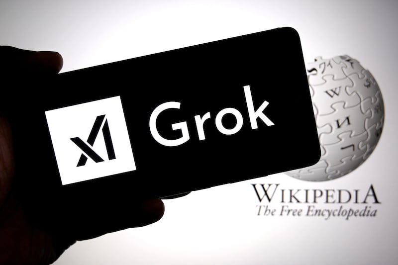 INDIA - 2025/09/15: In this photo illustration, the GROK AI logo is seen displayed on a smartphone with the Wikipedia logo in the background.